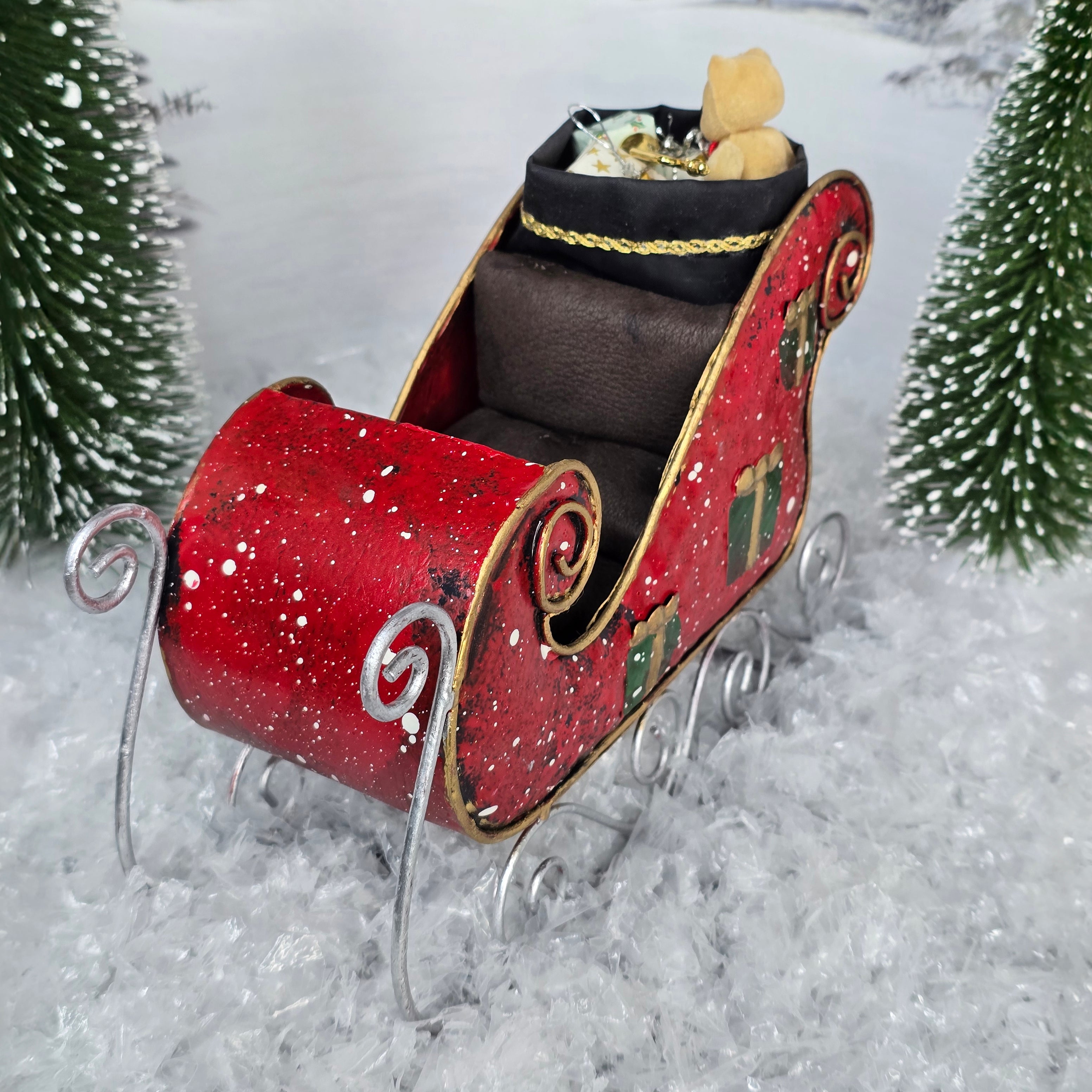 Red sleigh with a teddy bear on a snowy background