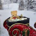Load image into Gallery viewer, Teddy bear in a red sleigh with presents against a snowy background
