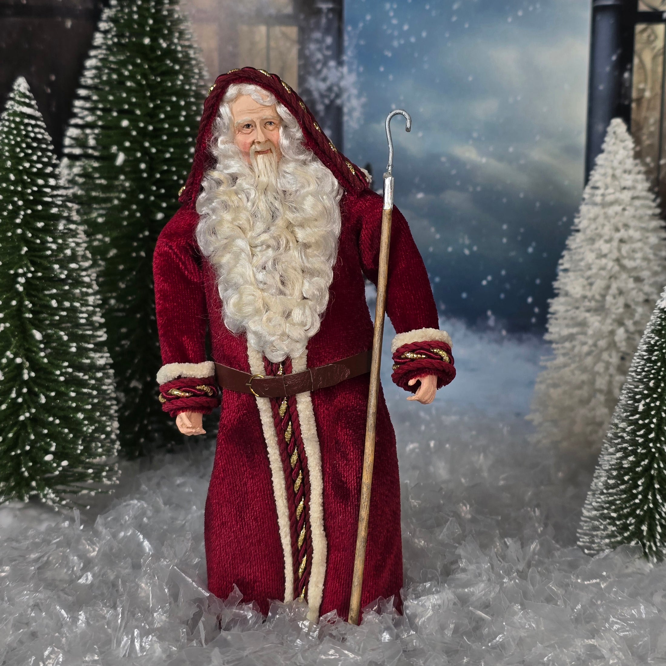 Santa Claus doll in a snowy landscape with trees and a dark sky.