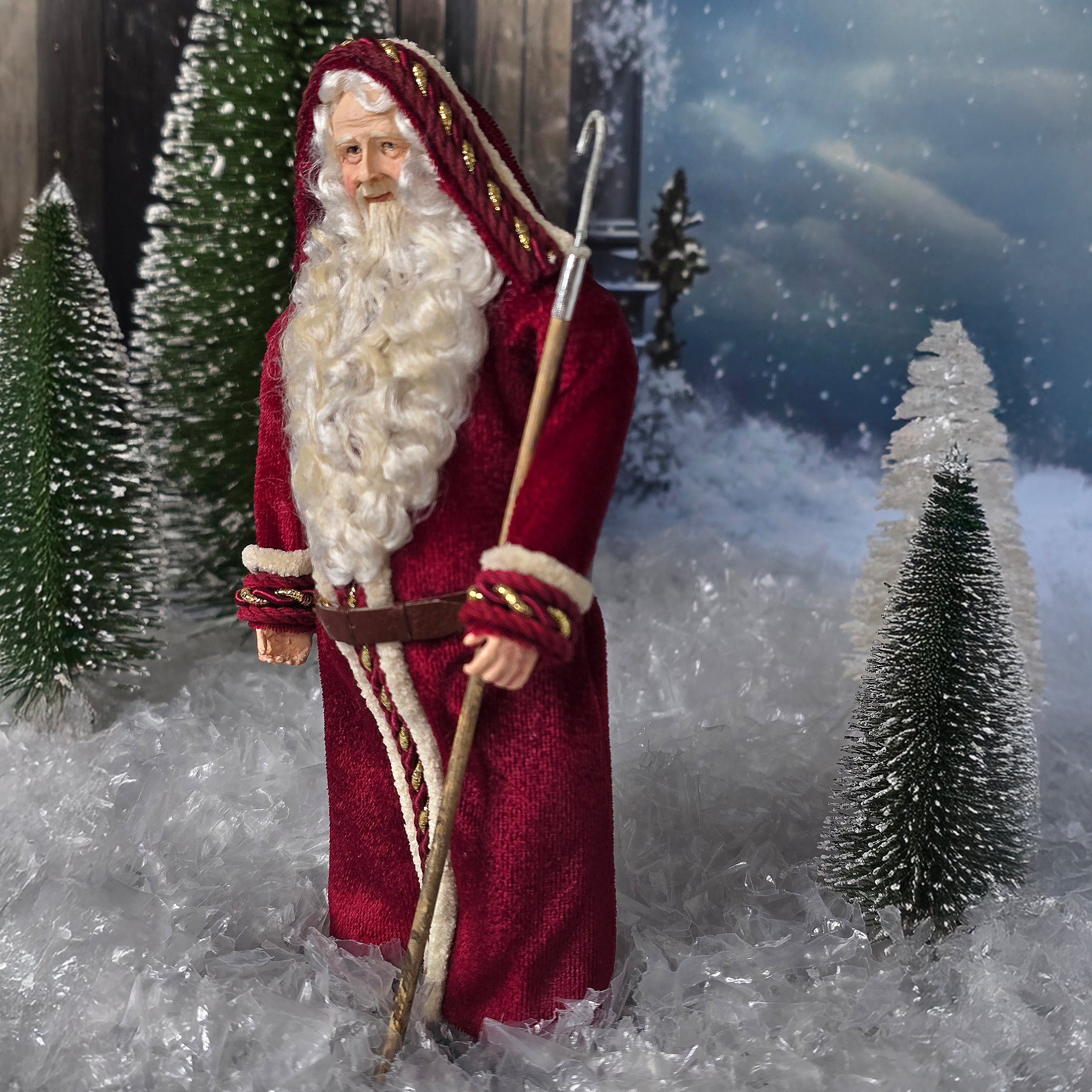 Santa Claus doll in a snowy landscape with trees and a dark sky.