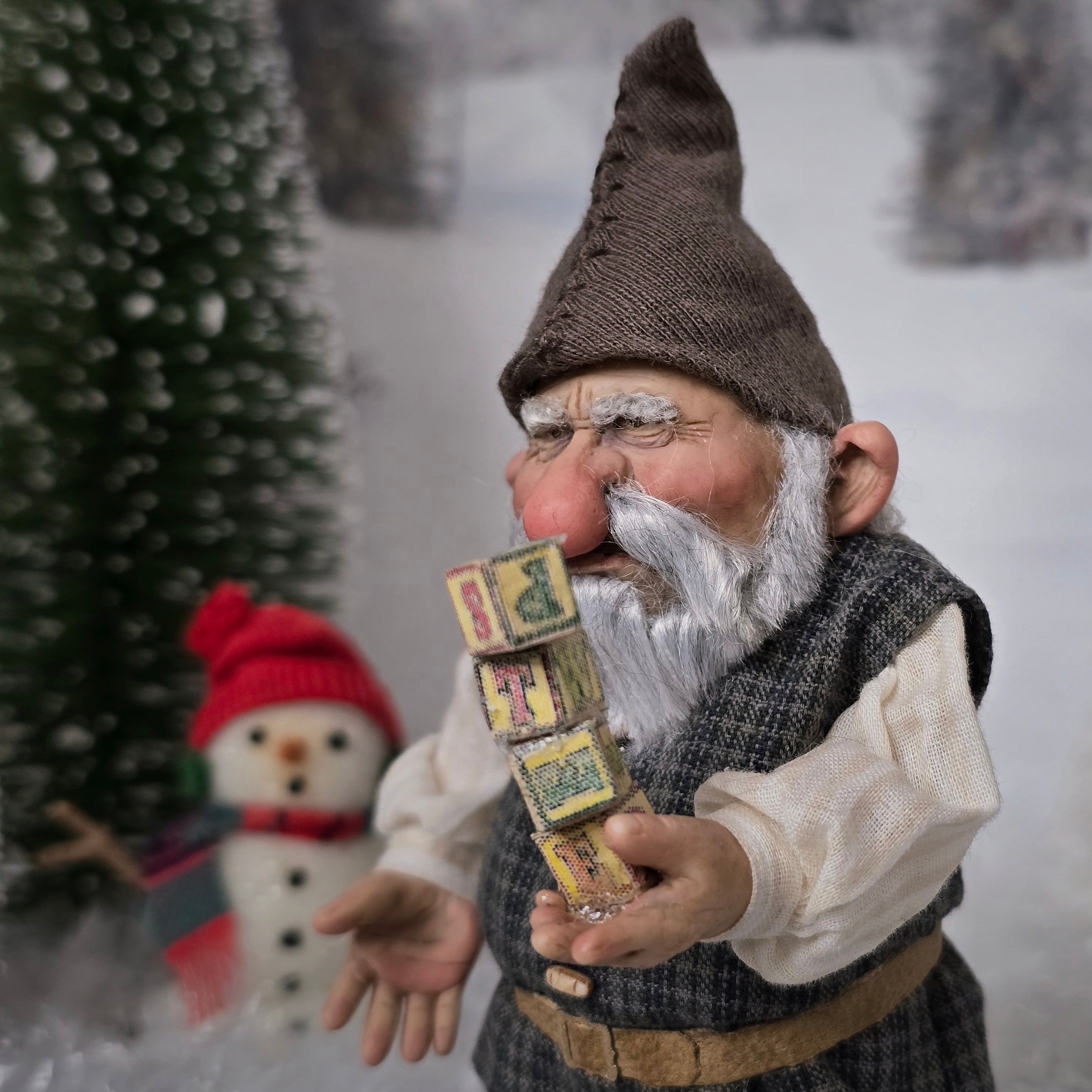 Sharon Cariola Elf dollhouse doll  holding wooden blocks with letters, snowman in the background