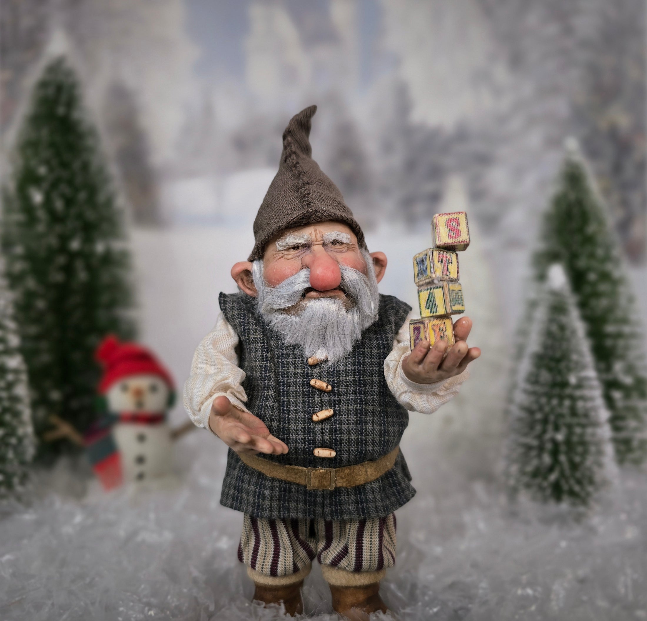 Sharon Cariola Elf dollhouse doll holding blocks with numbers in a snowy landscape