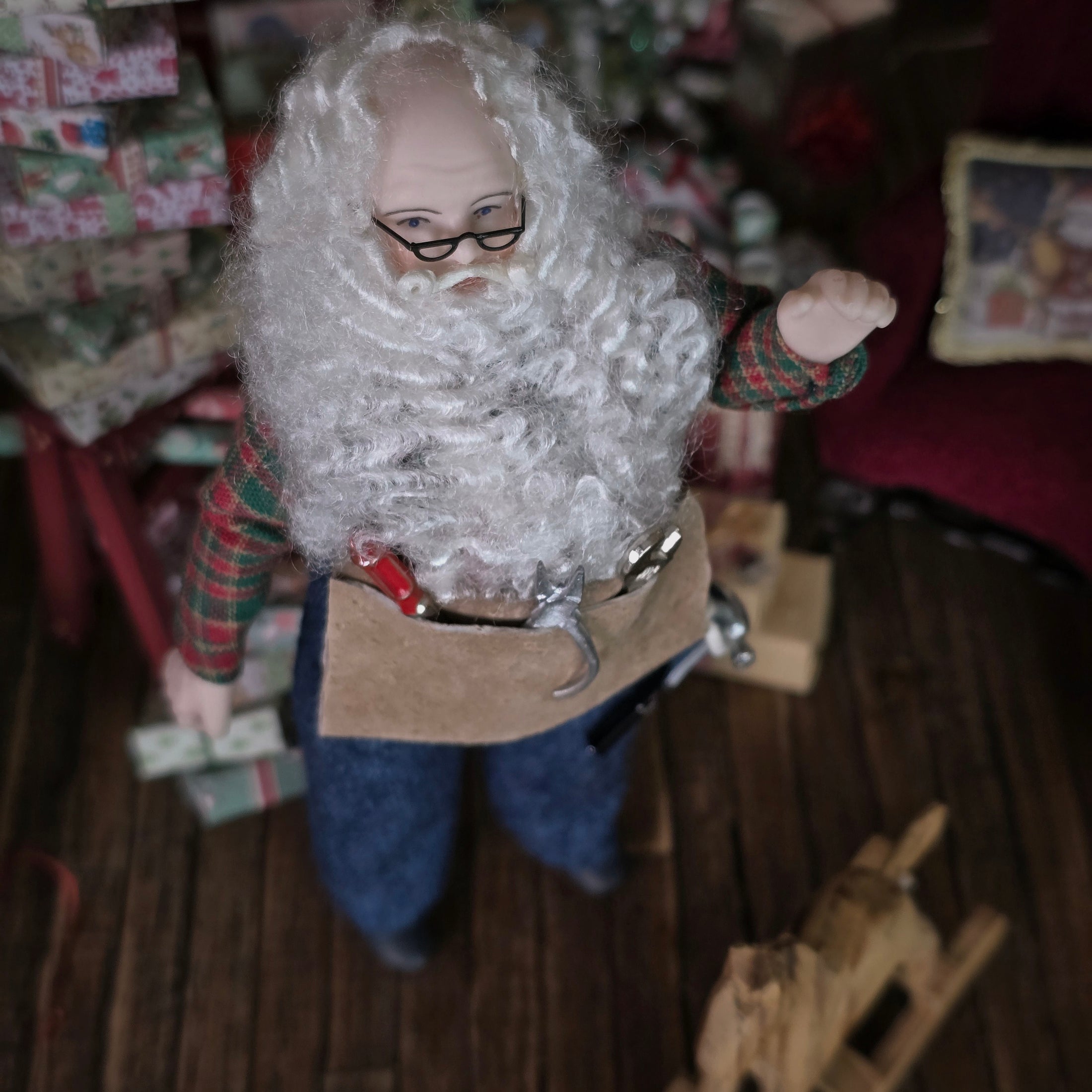 Dollhouse Doll Santa Claus with a long white beard and tool belt,  in a festive setting