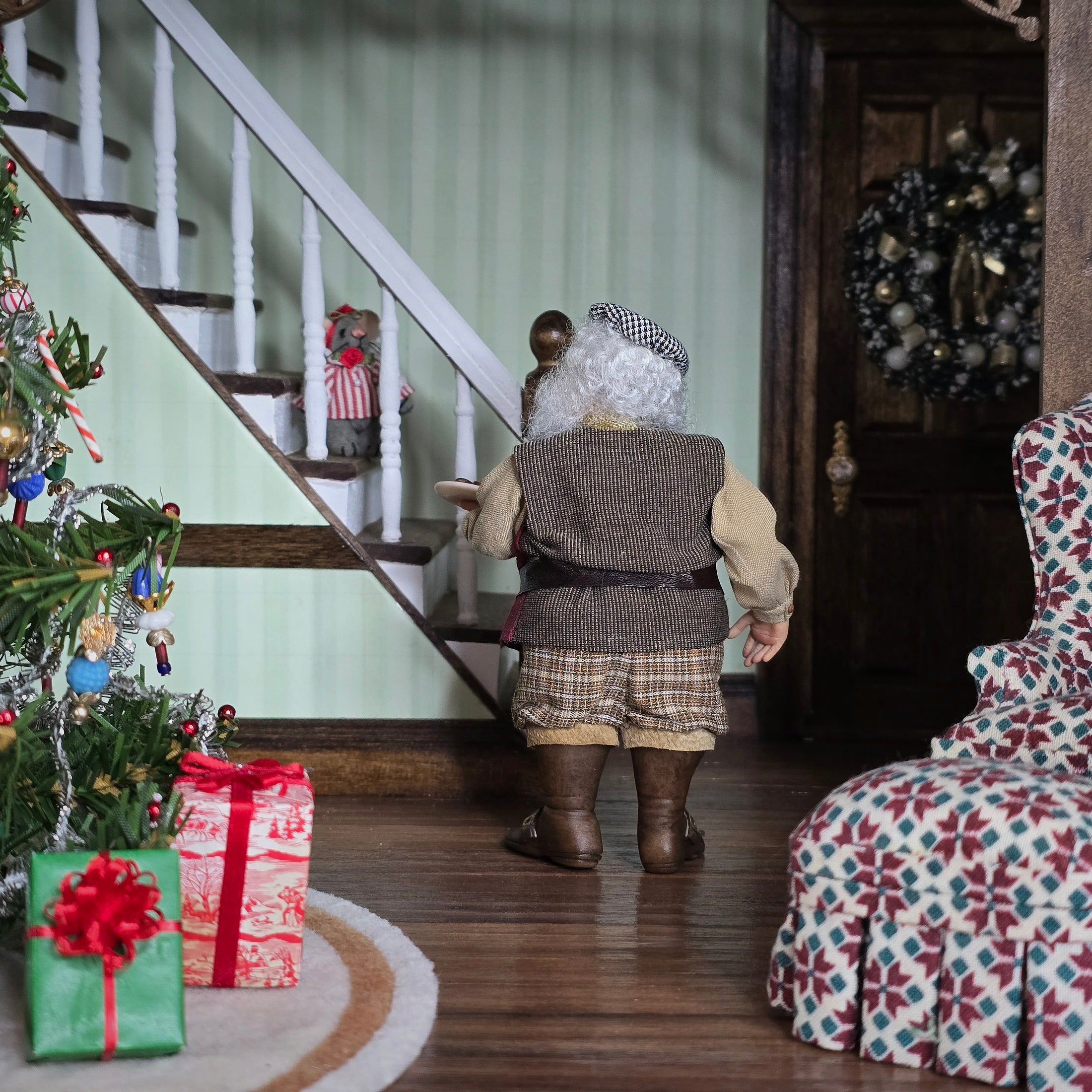 Old Christmas Elf doll in a festive room with Christmas decorations and presents.
