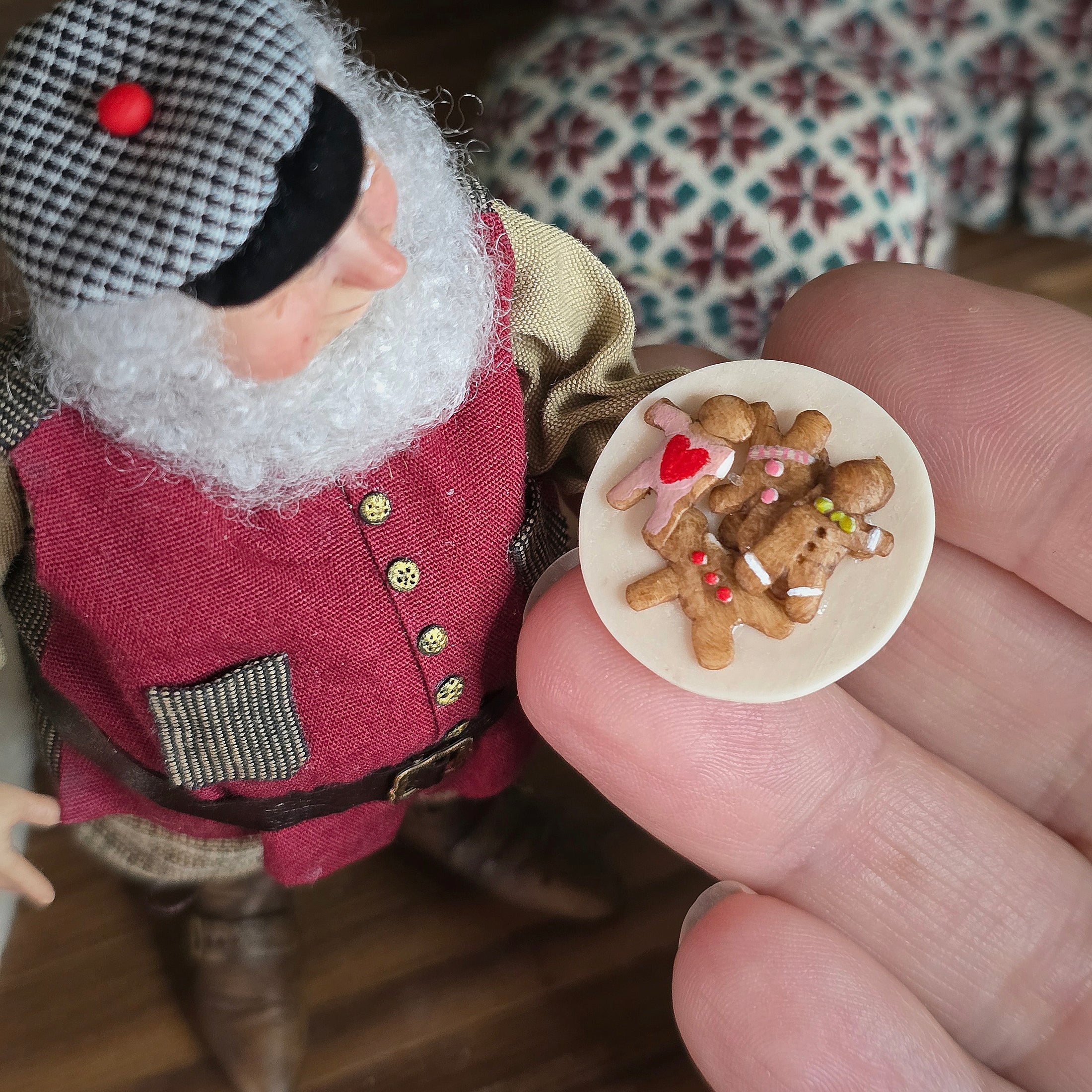 Old Christmas Elf doll with gingerbread cookies on a round plate held by a hand.
