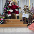 Load image into Gallery viewer, Decorative display with a seated Santa dollhouse doll in a red suit, reindeer, and Christmas trees.
