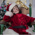 Load image into Gallery viewer, Santa dollhouse doll in a red costume with white fur trim sitting on a decorative chair.
