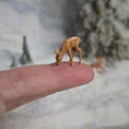 Load image into Gallery viewer, Miniature deer figurine on a person's finger with a blurred snowy background
