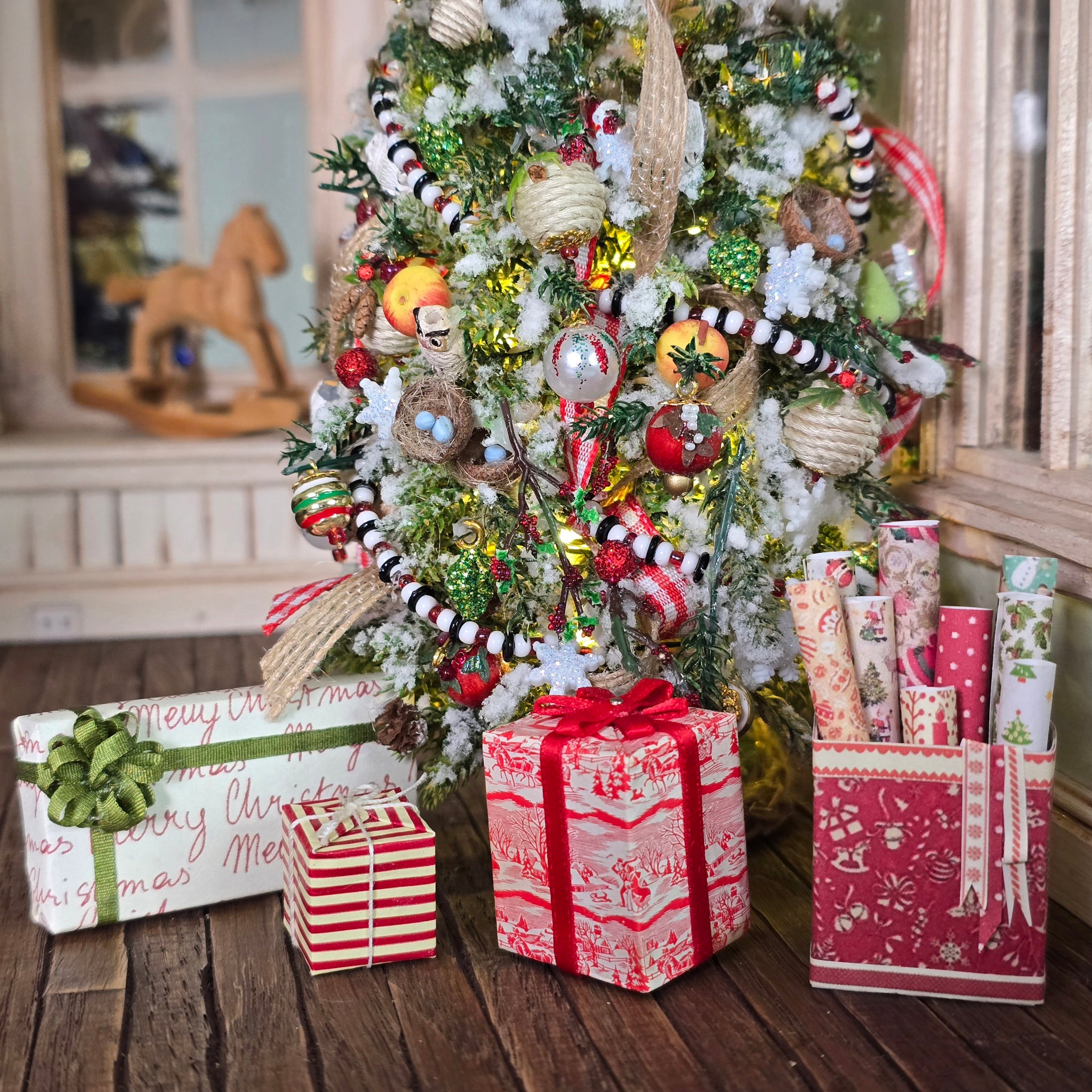 Decorated Christmas tree with ornaments and presents on a wooden floor.