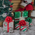 Load image into Gallery viewer, Decorative Christmas presents with red and green ribbons in front of a small Christmas tree.
