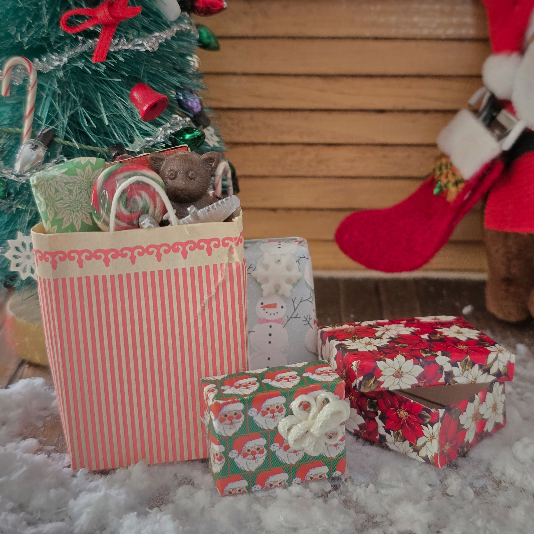 Christmas scene with wrapped gifts, a small tree, and a Santa Claus figure.