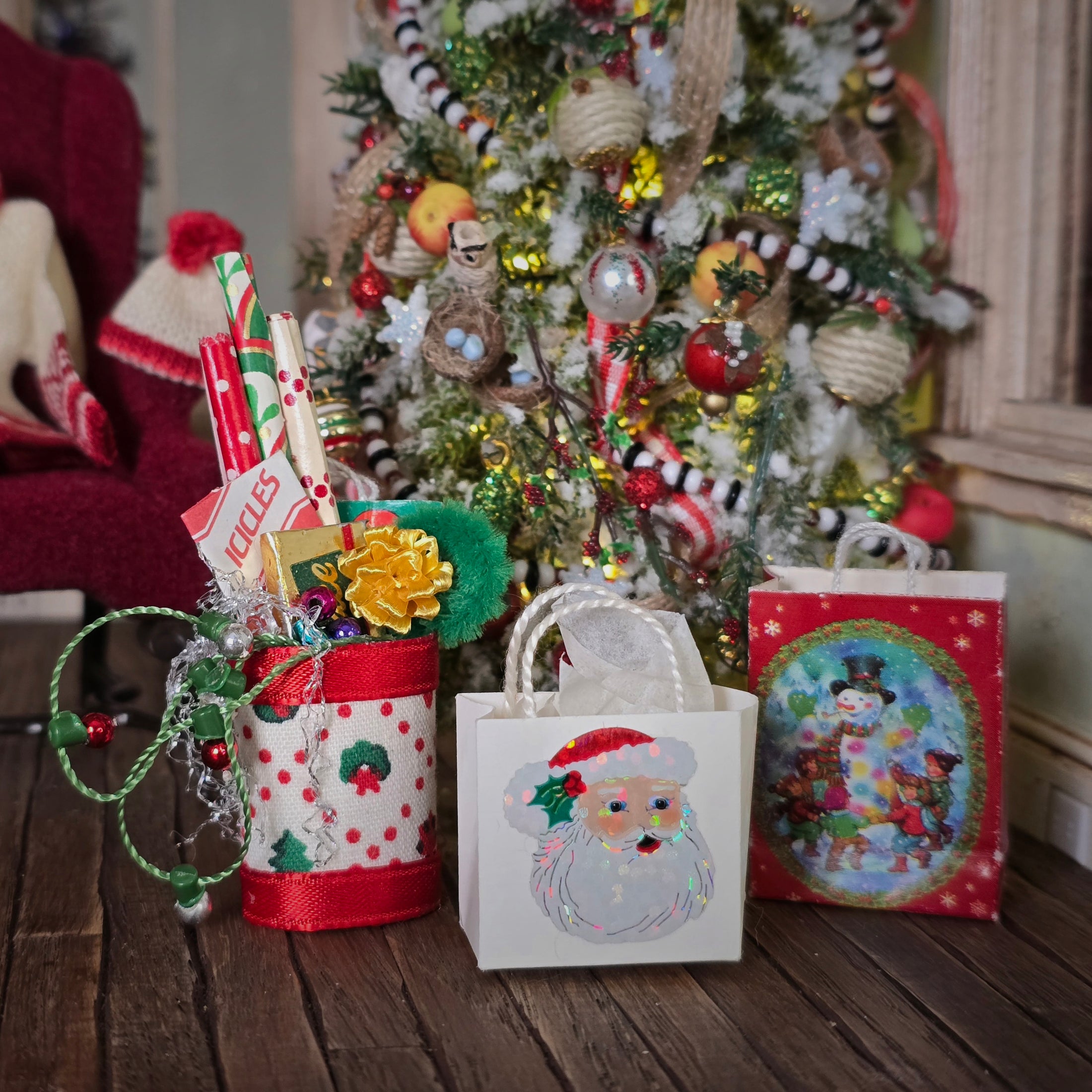 Decorative Christmas items including a gift bag with a Santa Claus design in front of a decorated tree.