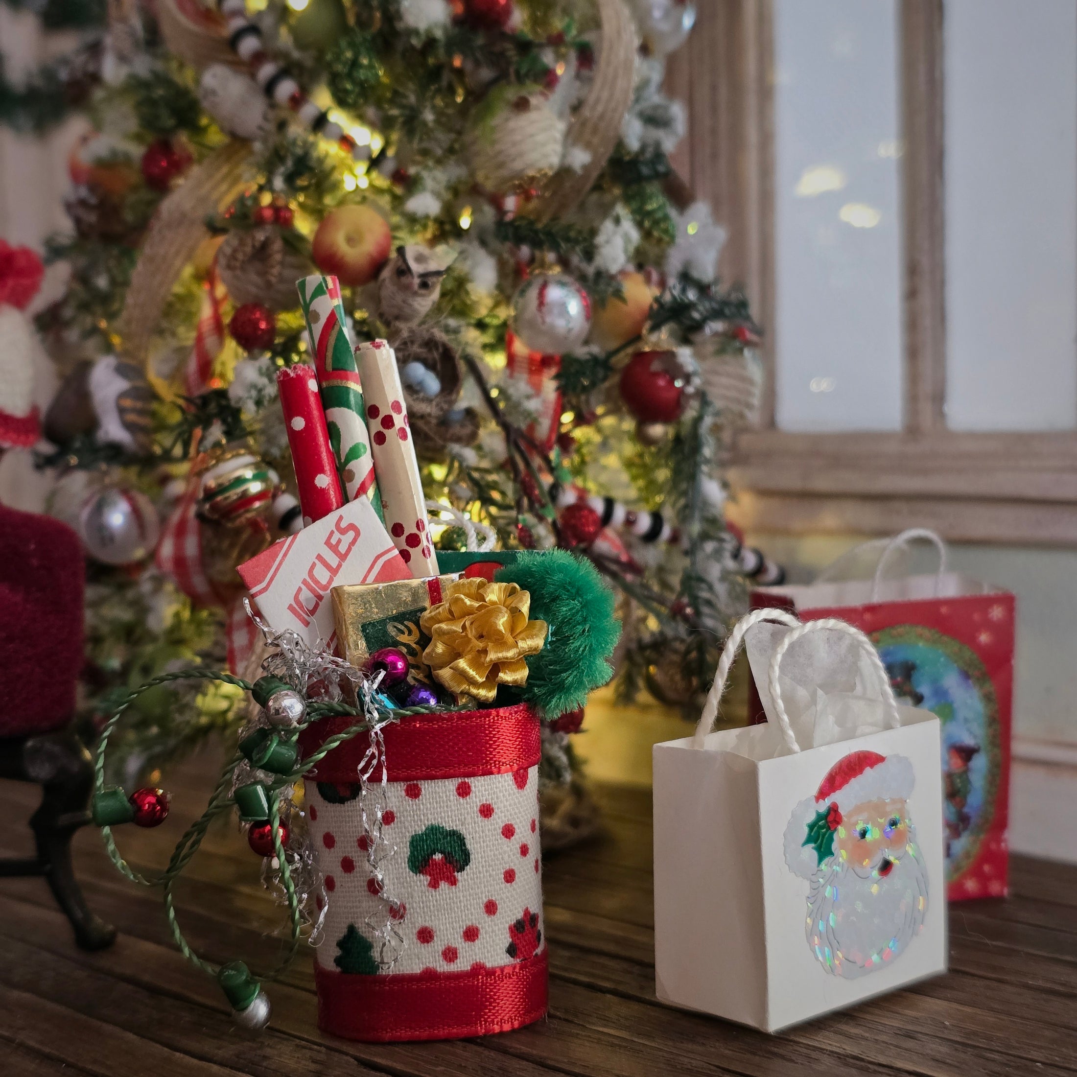 Decorative gift basket with a small bag featuring a Santa Claus design in front of a Christmas tree.