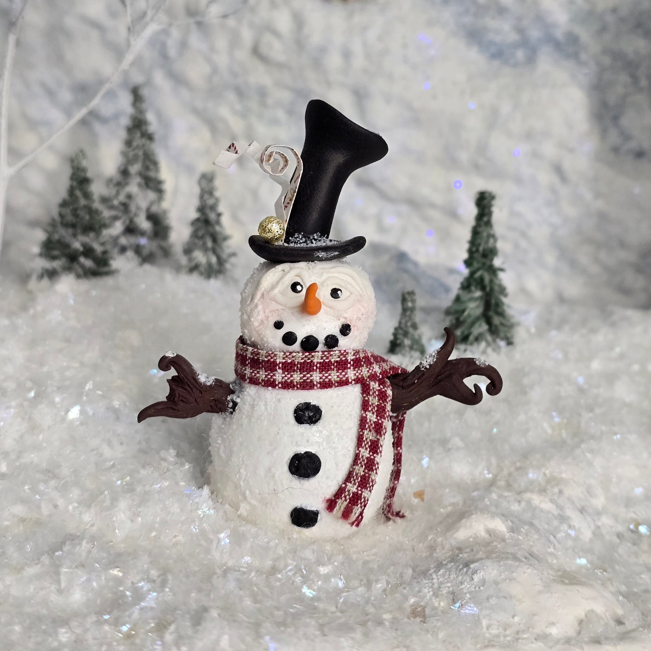 Decorative snowman miniature with a top hat and scarf against a snowy background