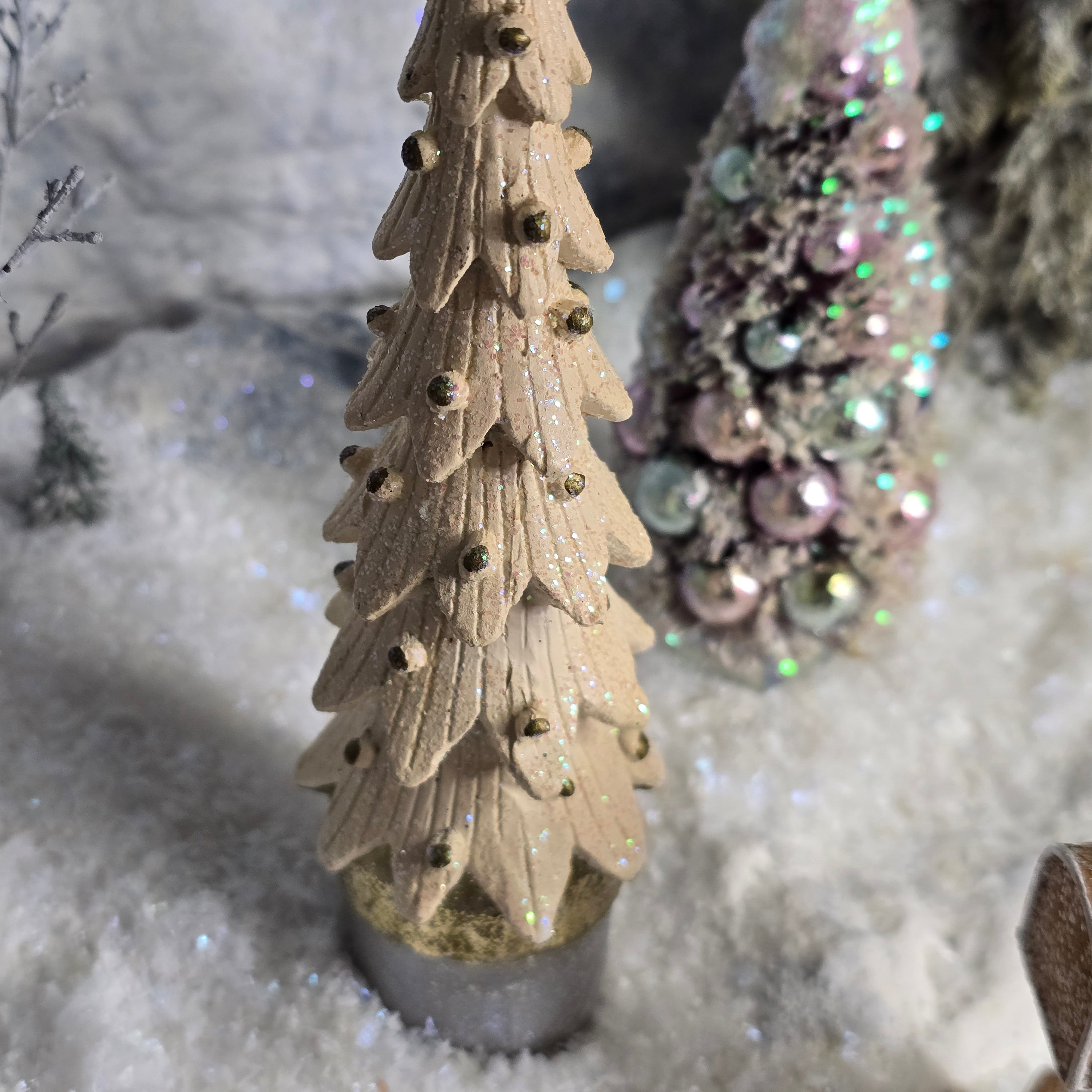 Decorative Christmas tree miniature with a glittery finish on a snowy background