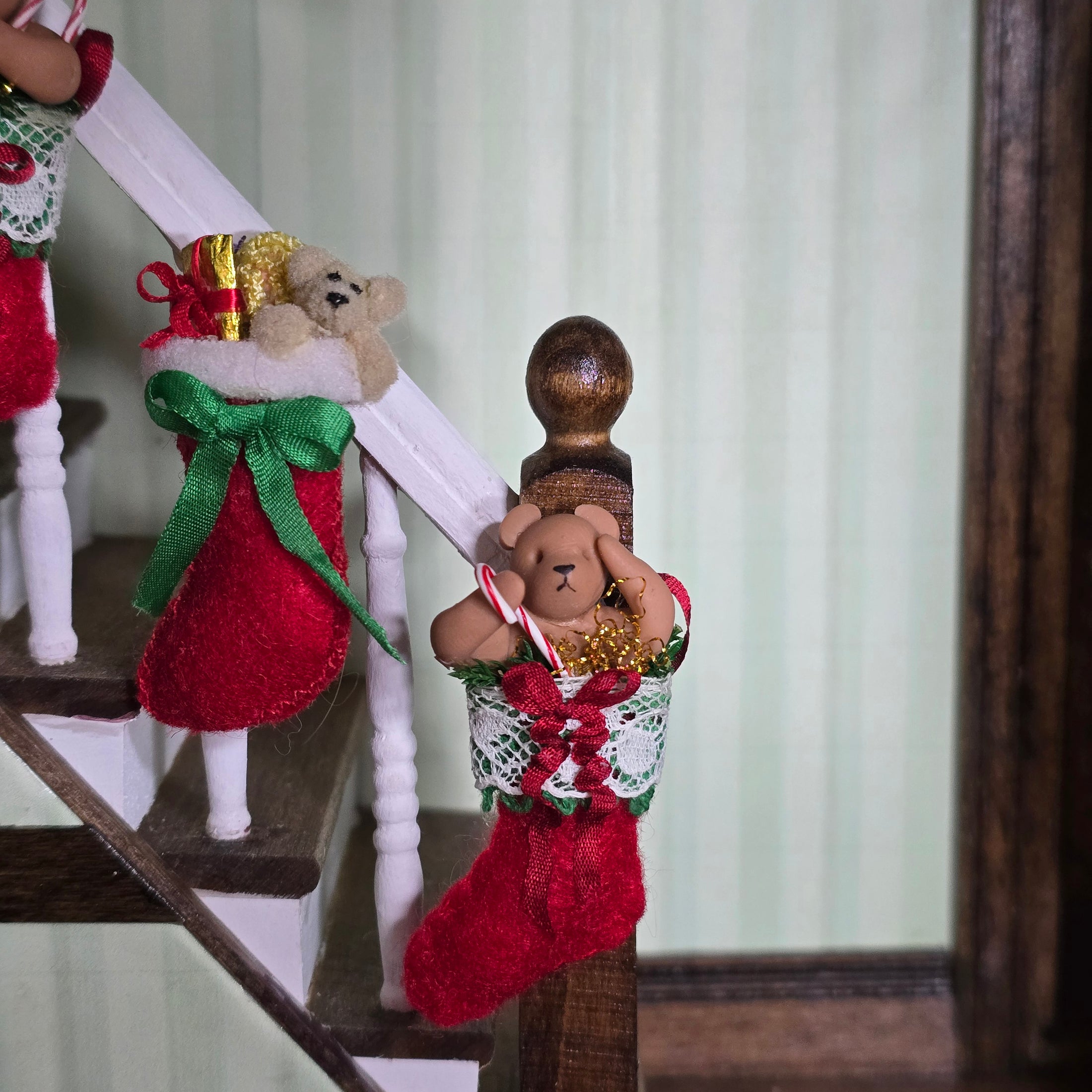 Decorative Christmas stockings with teddy bears on a staircase.