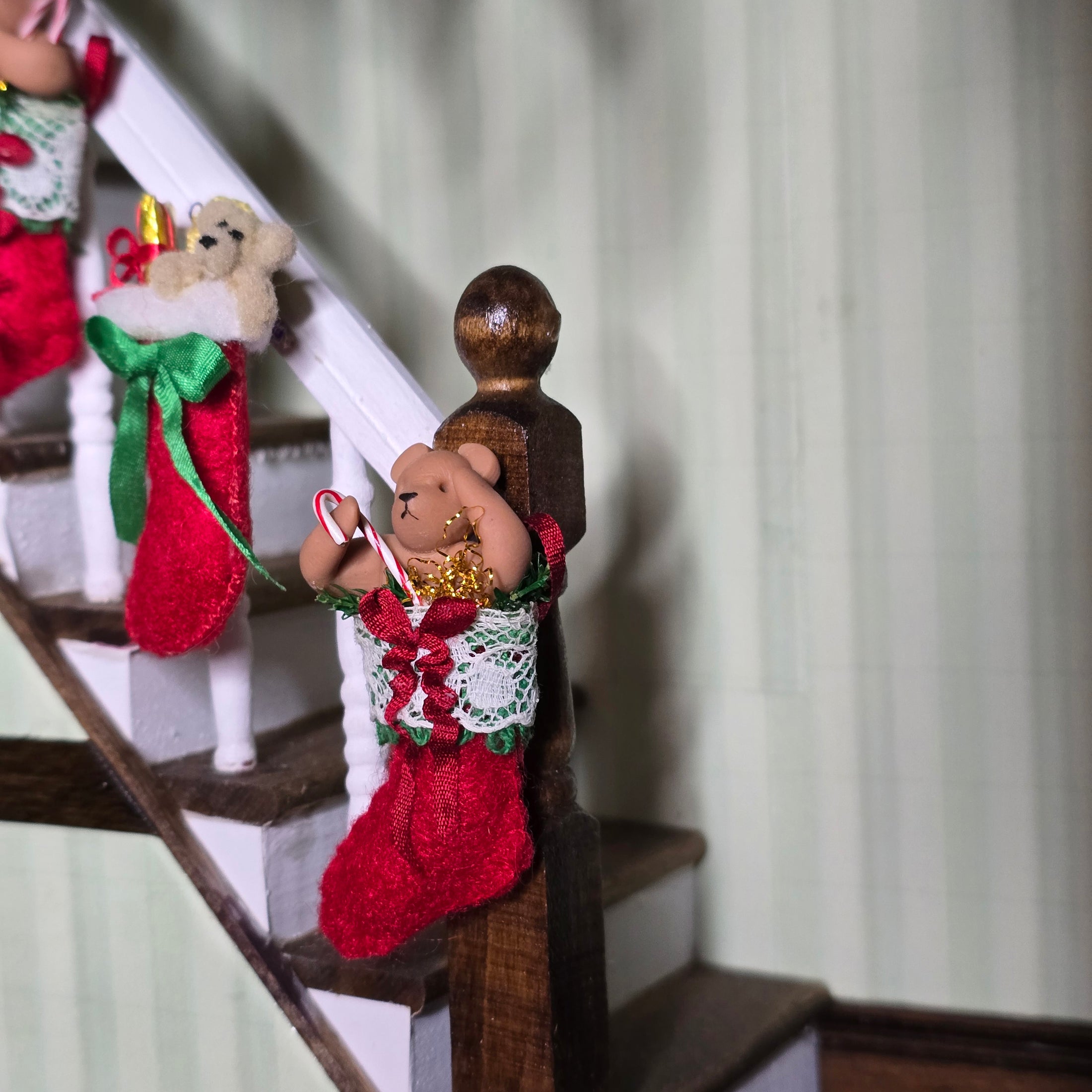 Red Christmas stockings with teddy bears on a staircase