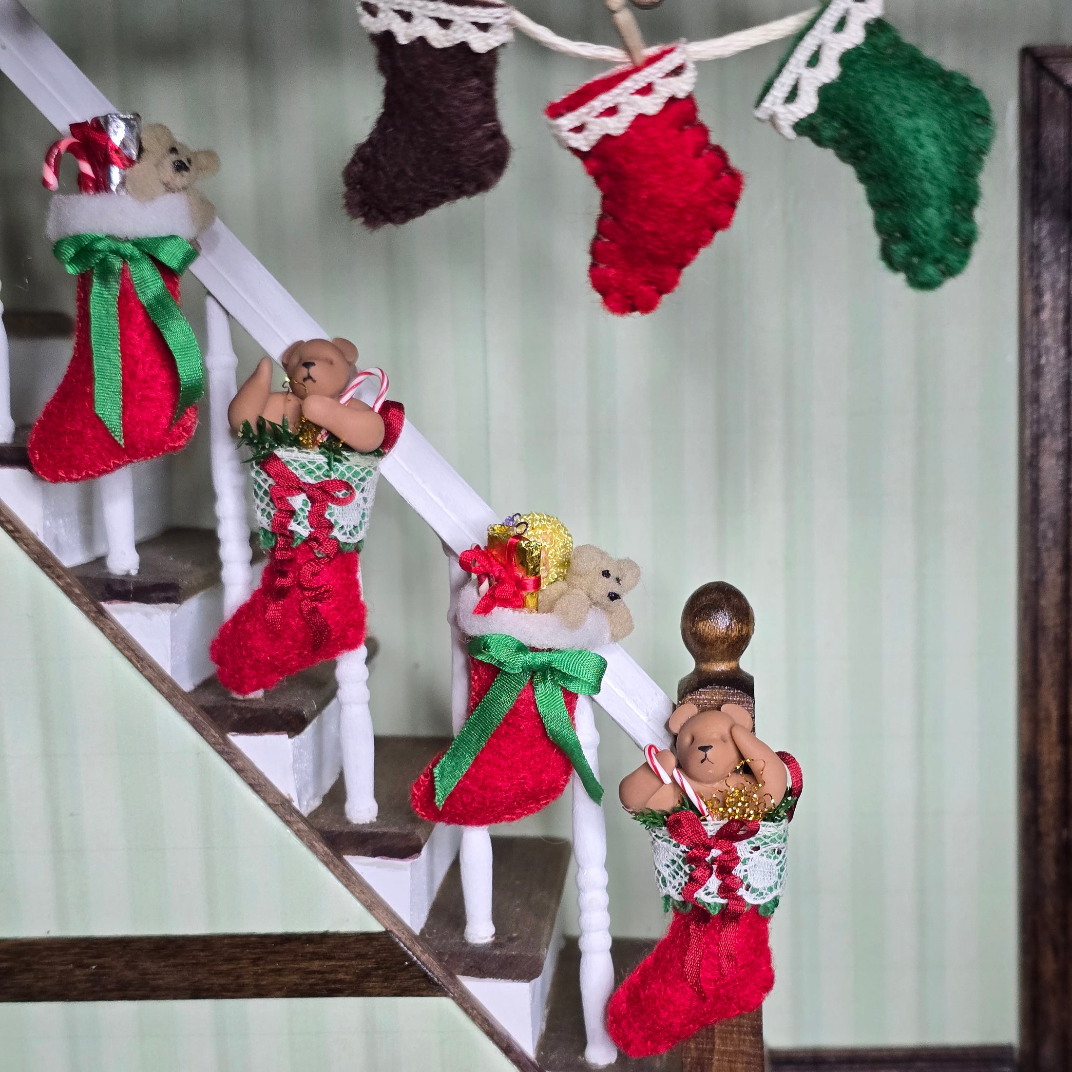 Decorative Christmas stockings with teddy bears on a staircase.