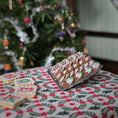 Load image into Gallery viewer, Decorative cookies on a festive tablecloth with a Christmas tree in the background
