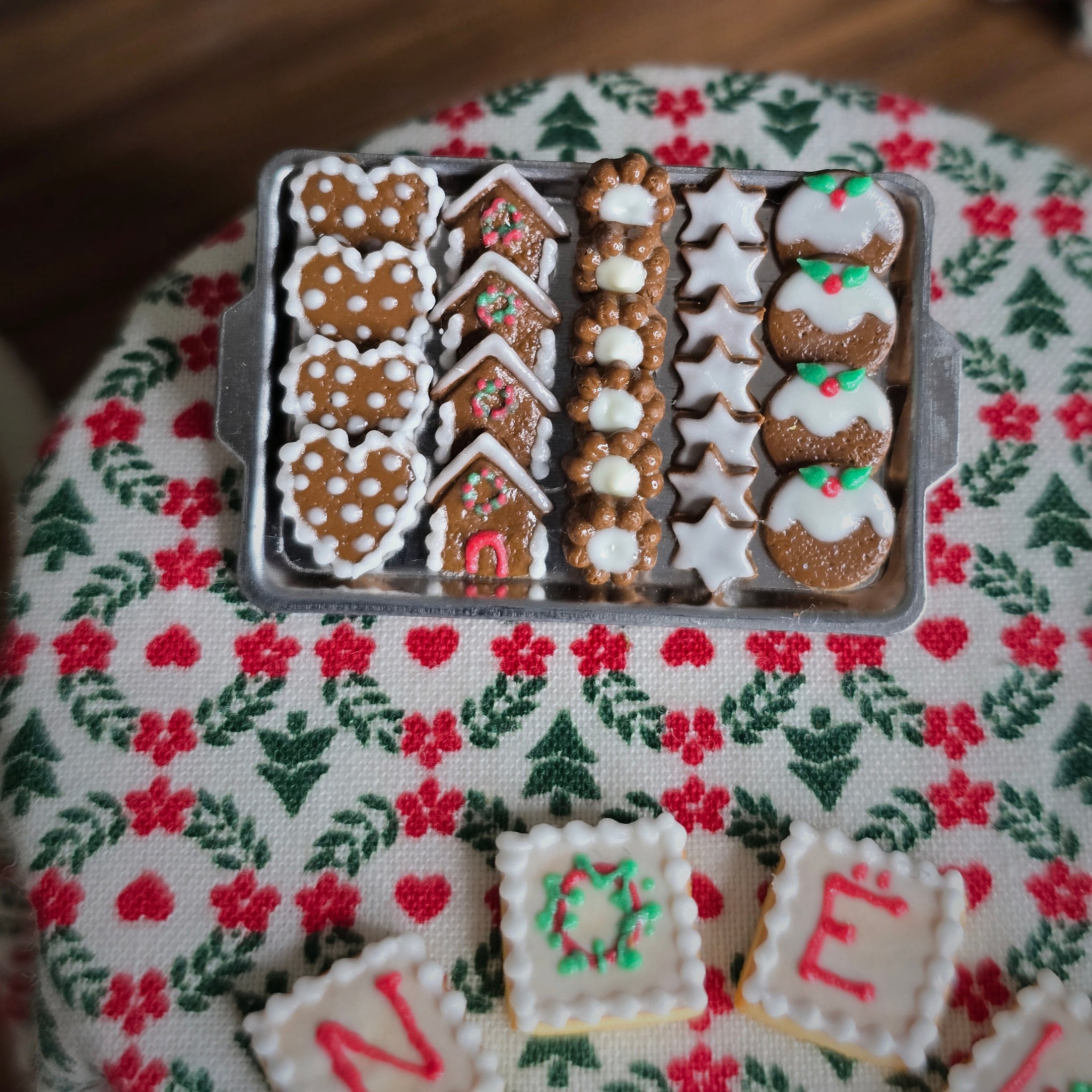 Decorative gingerbread cookies in a tin on a festive fabric background
