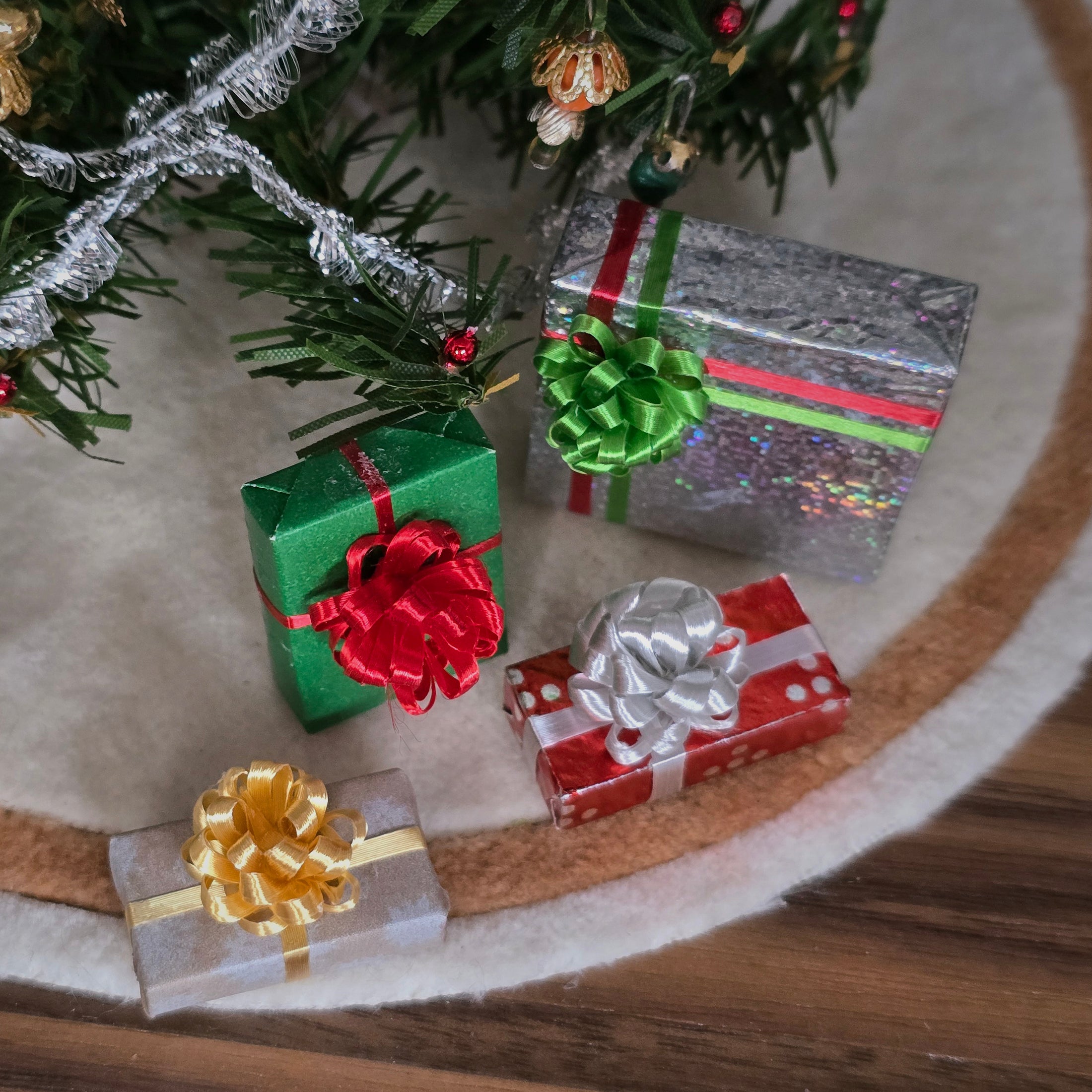 Miniature Christmas presents with ribbons on a wooden surface
