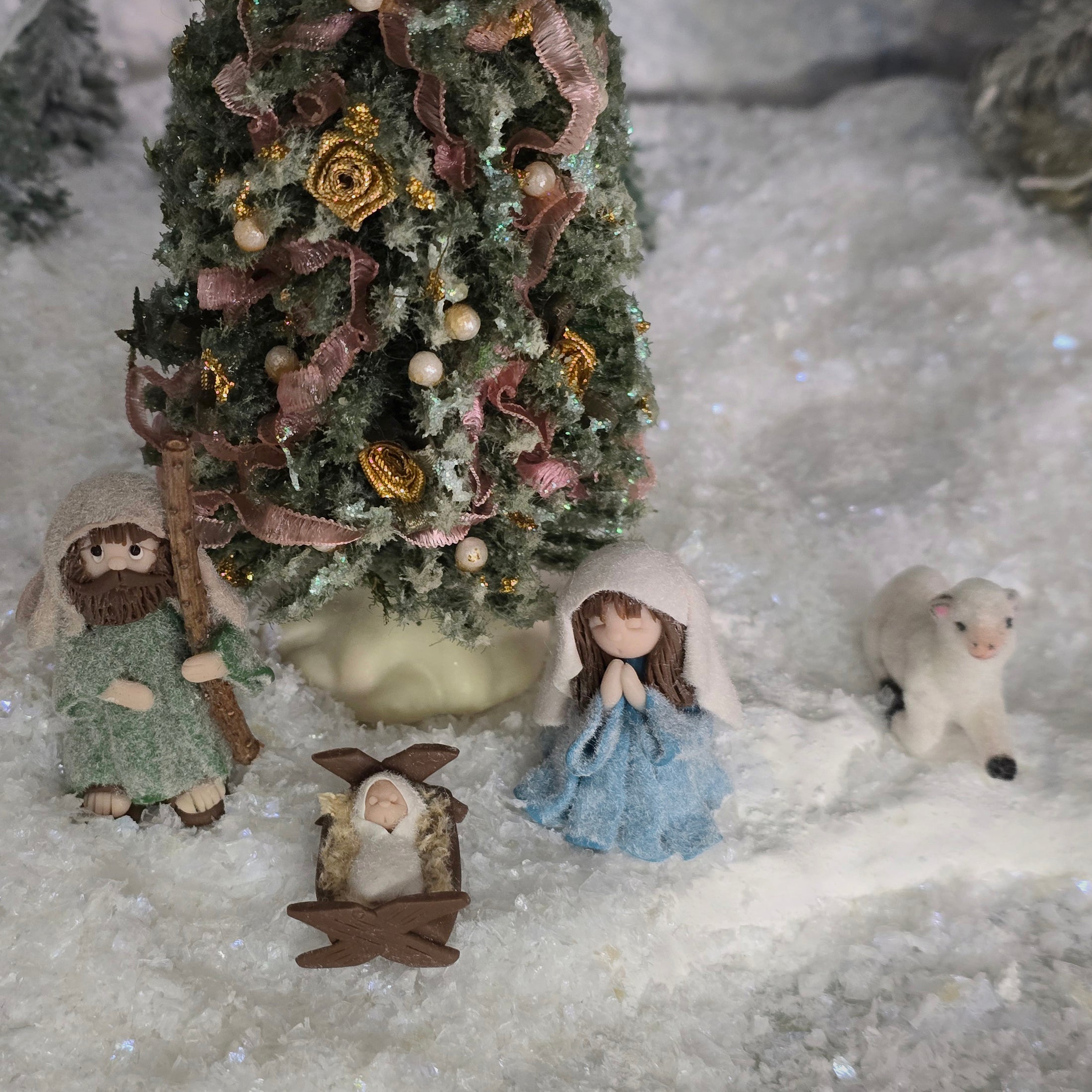 Nativity scene with figures and a decorated Christmas tree in a snowy setting miniature dollhouse