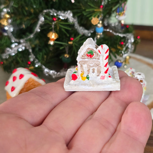 miniature gingerbread house held on hand