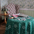 Load image into Gallery viewer, close-up shot of Green tablecloth with snowflake patterns on a table, with decorative items in the background.
