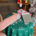 Load image into Gallery viewer, Metal Christmas tree-shaped cookie cutter on a finger for a close-up.

