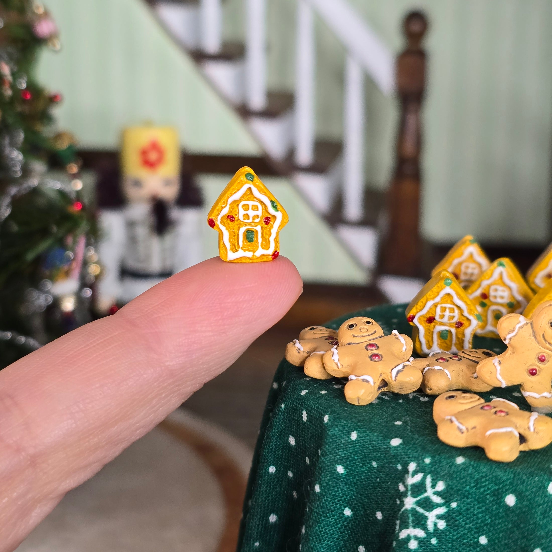 miniature gingerbread house on finger
