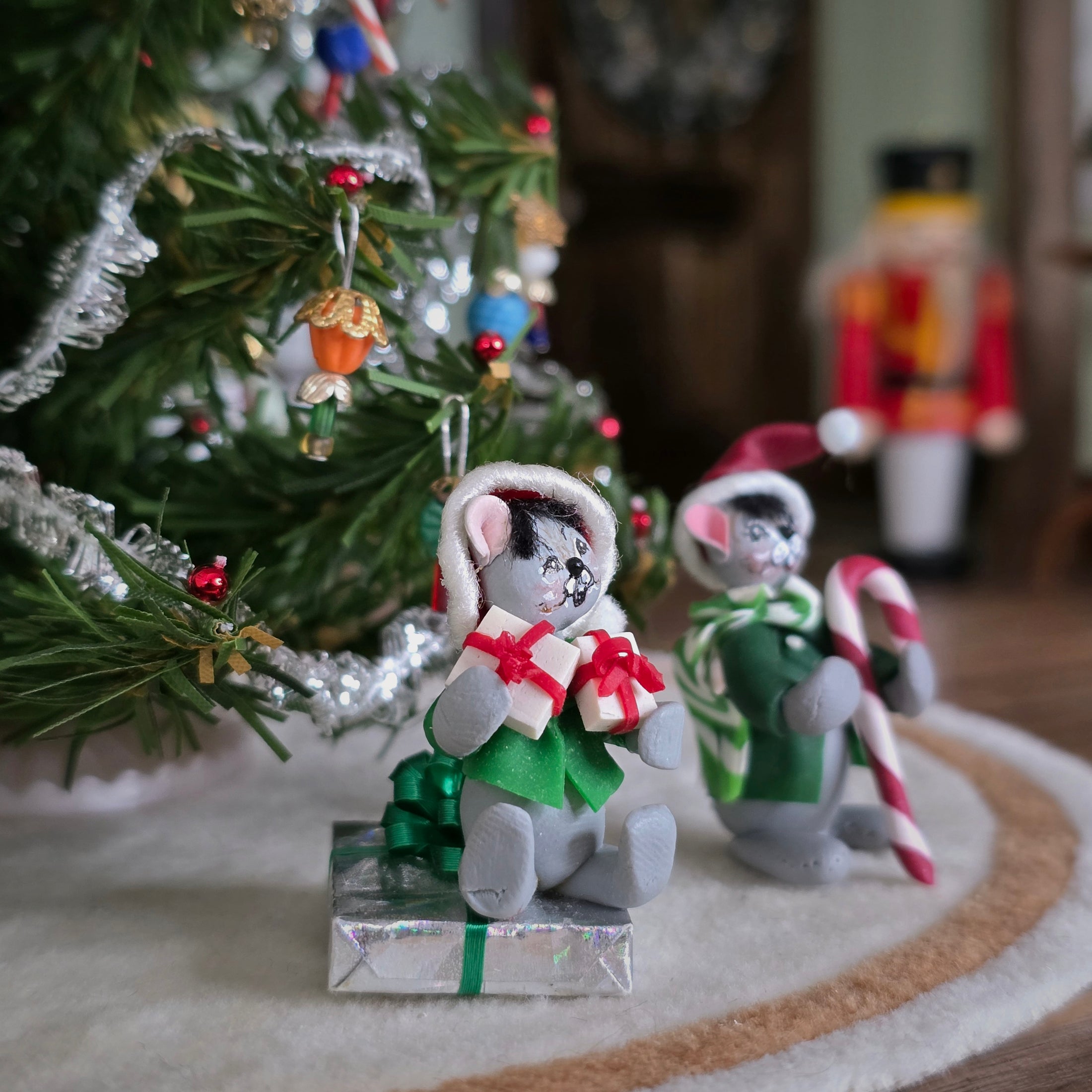 Christmas-themed Annalee style mice figurines in front of a decorated tree