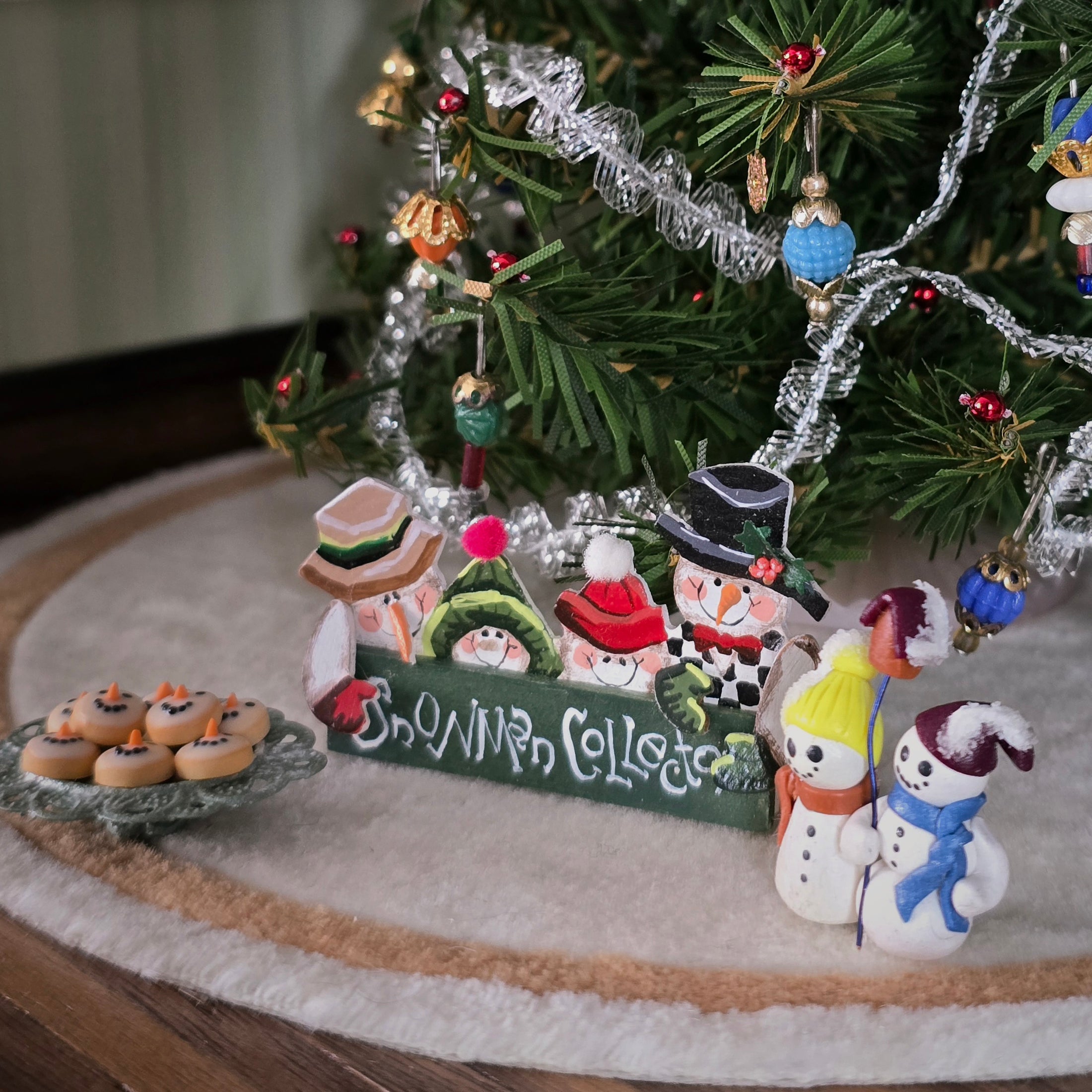 miniature dollhouse snowmen-themed sign, shelf sitter and cookie platter, under tree