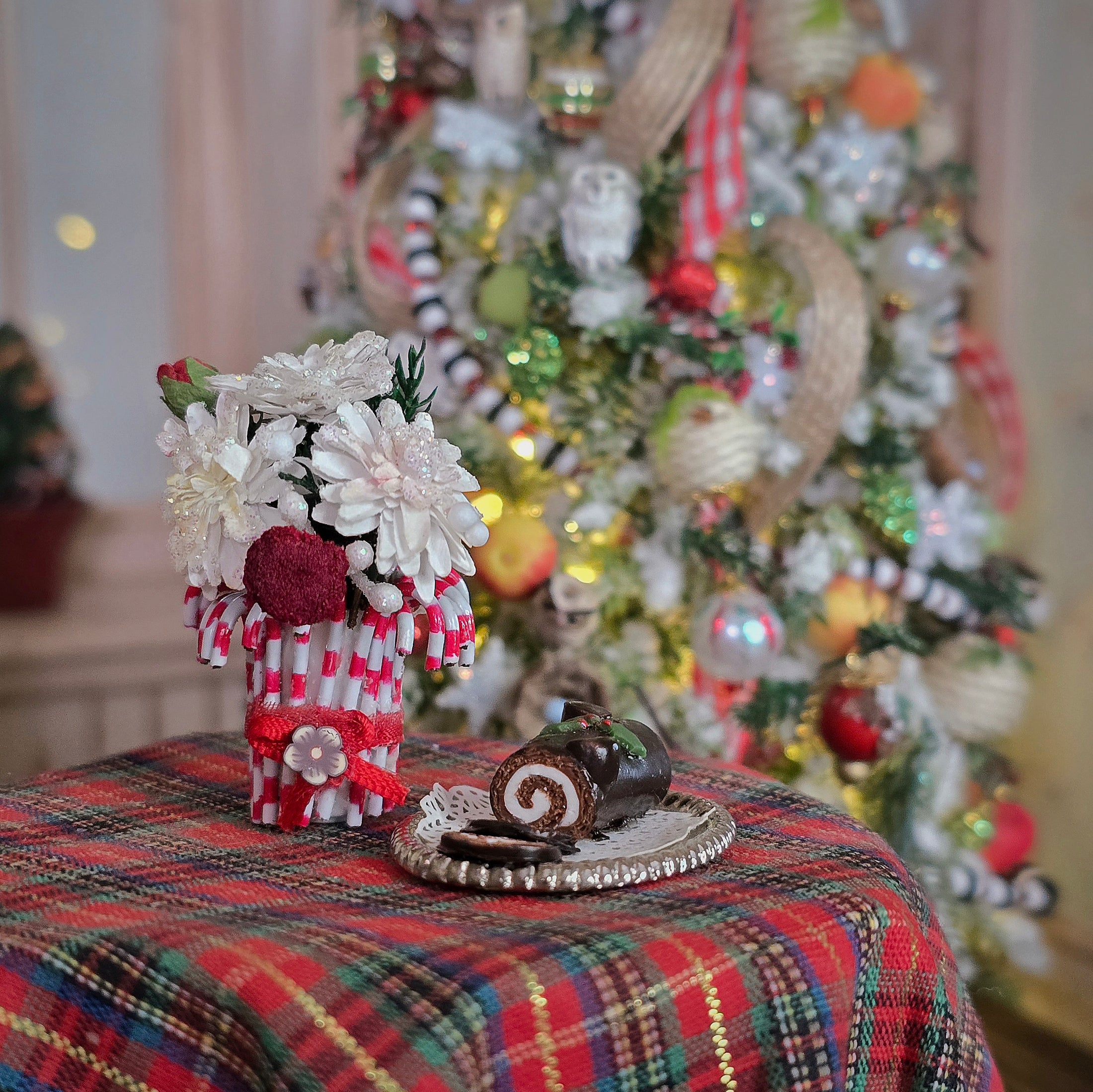 vase of flowers, yule log cake on a table