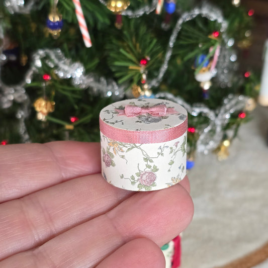 close up of one of the miniature hat boxes with pink ribbon