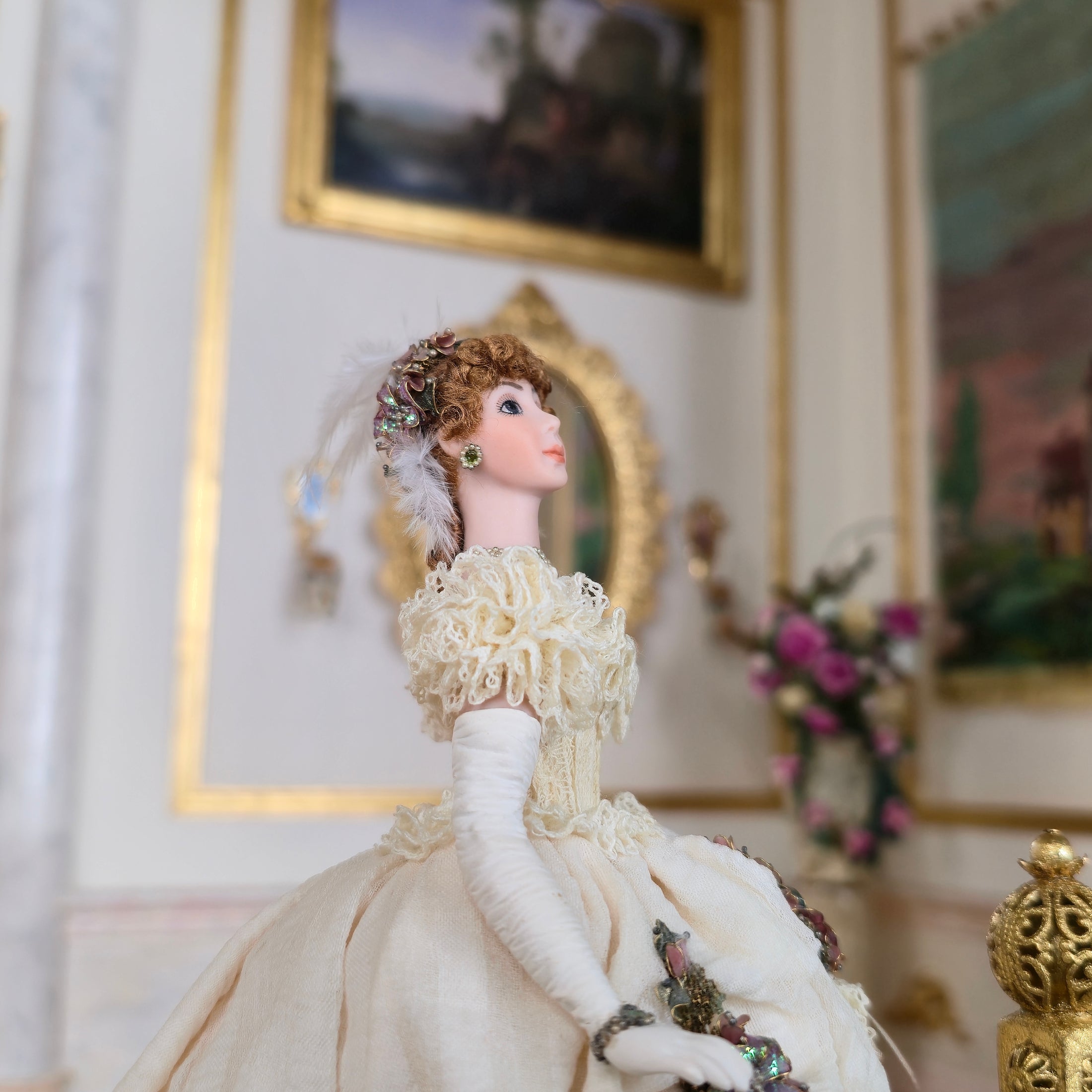 side view of Stacy Hoffman doll with paintings and a mirror.