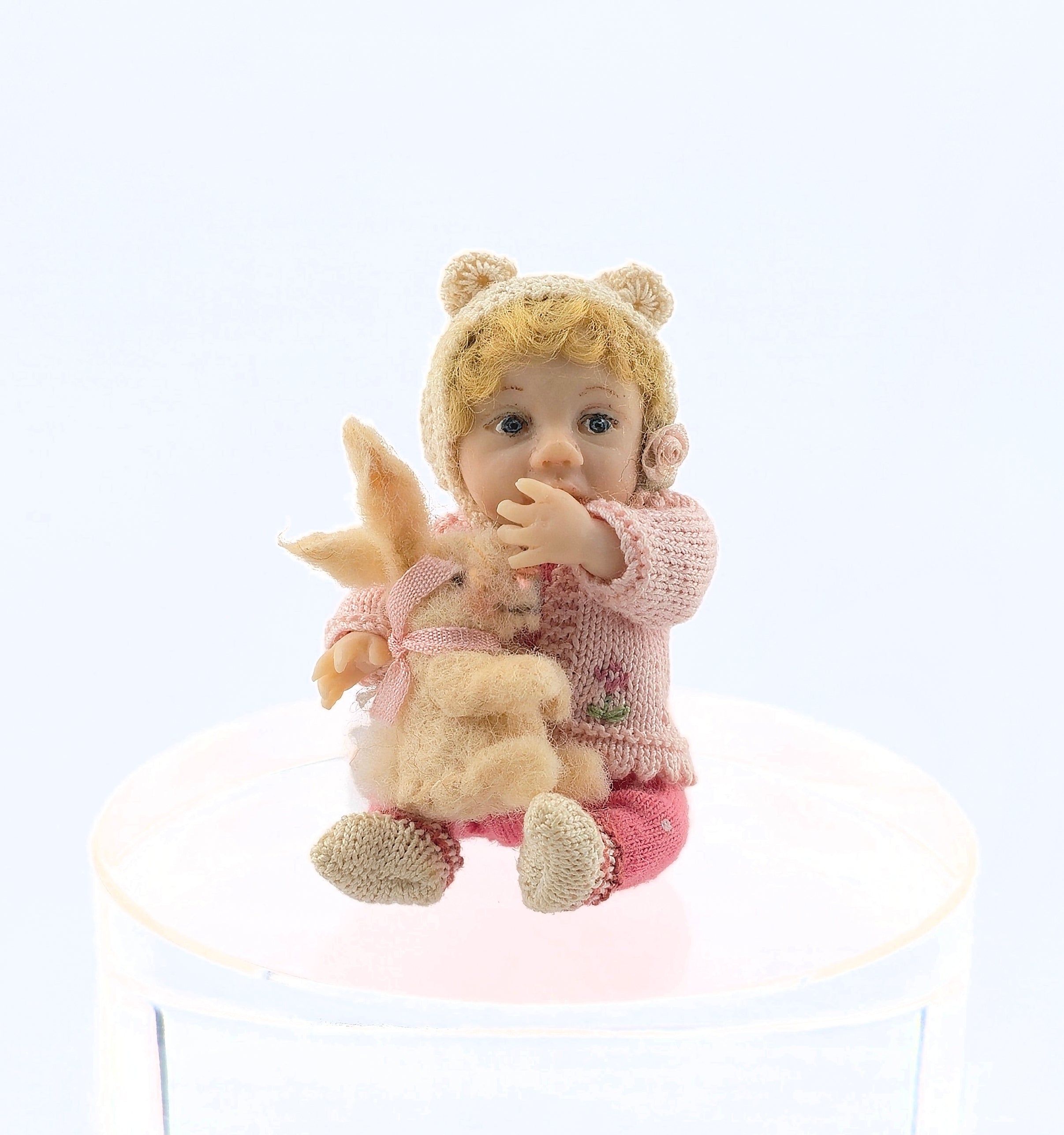 Catherine Muniere doll with blonde hair, wearing a knitted outfit on a white background.