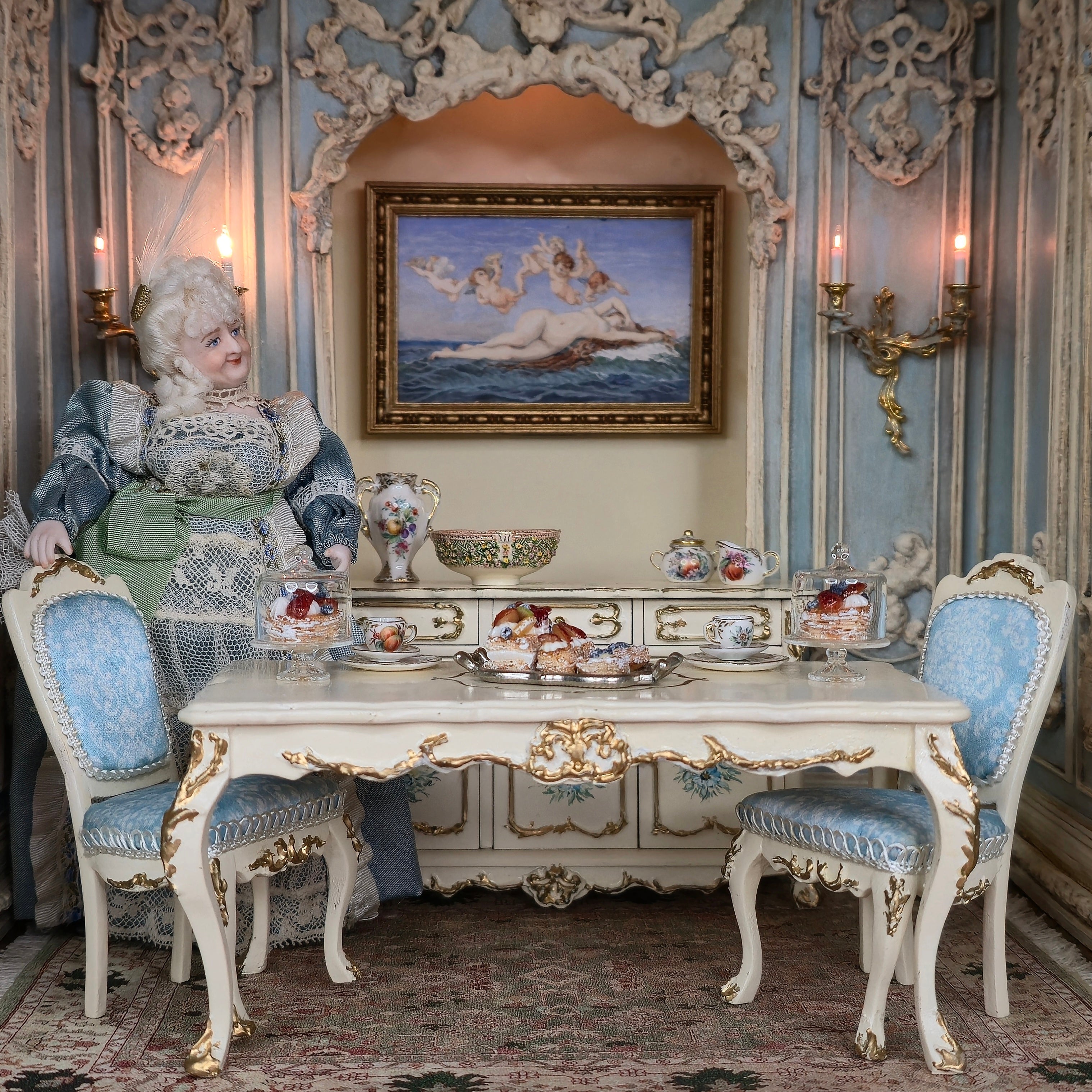 Decorative miniature interior with ornate furniture, a doll, and decorative items.