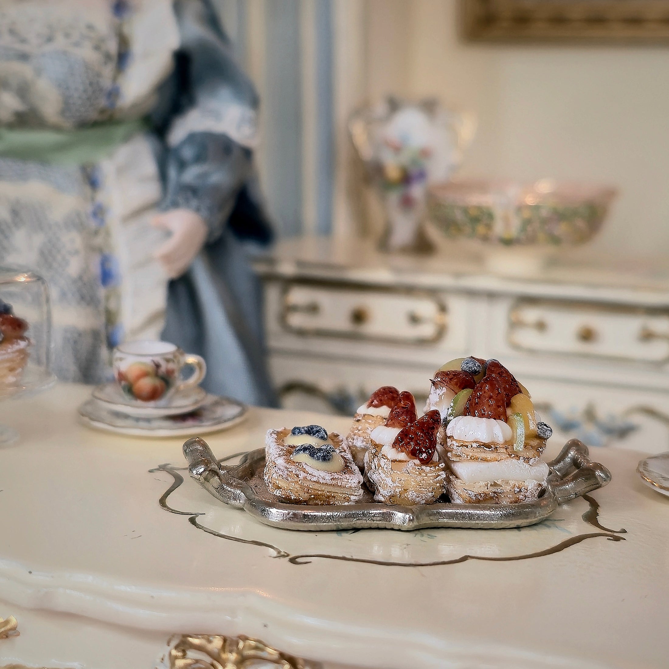 Miniature pastries on a silver tray with a decorative background