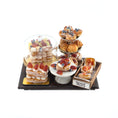 Load image into Gallery viewer, Assorted miniature pastries on a tiered stand with a sign indicating 'Denish pastry' on a white background.
