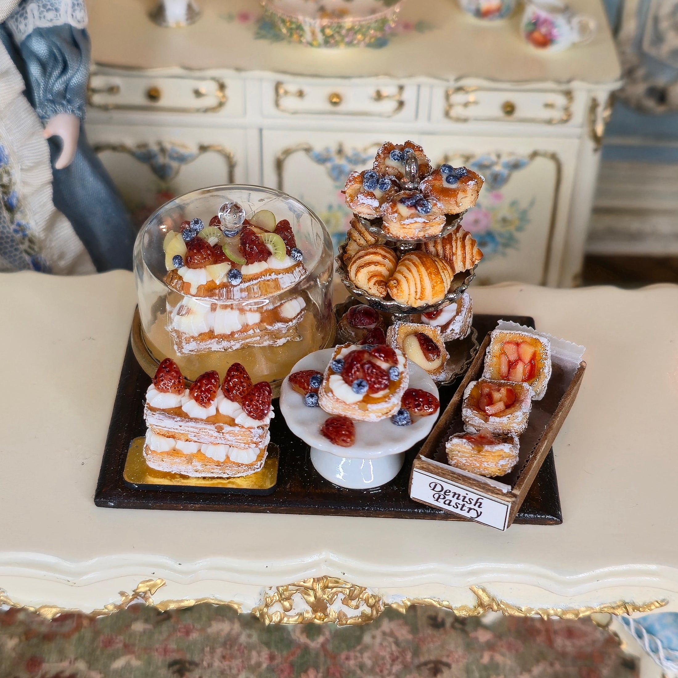 Miniature pastries on a decorative tray with a vintage setting