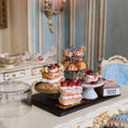 Load image into Gallery viewer, Three-tiered dessert stand with pastries on a decorative table.
