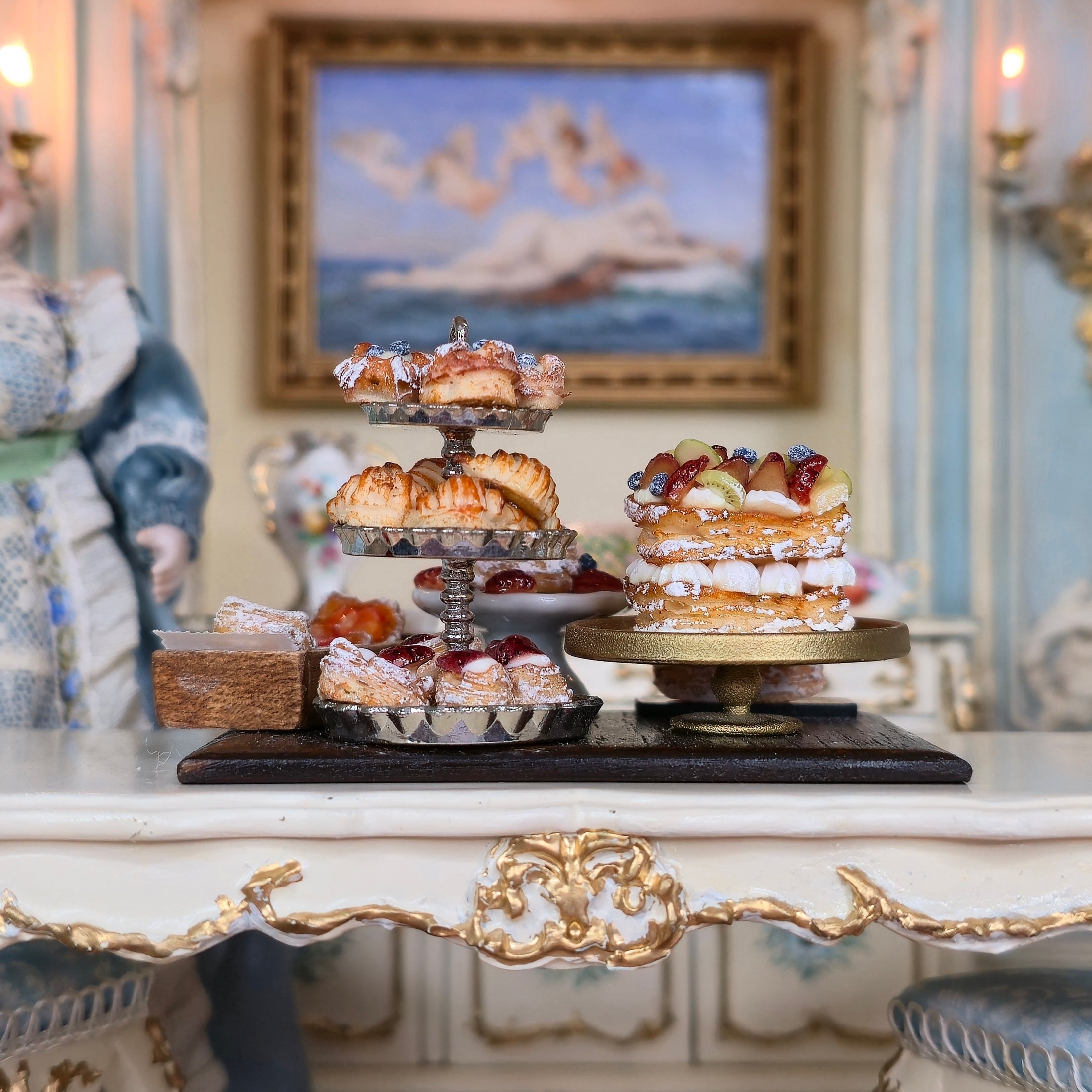 Three-tiered dessert stand with pastries on a decorative table in an elegant room.