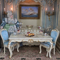 Load image into Gallery viewer, Miniature dollhouse scene with a dining table, chairs, and a doll in an ornate room.

