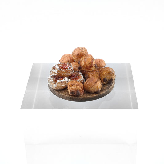 Miniature pastries on wooden serving board, white background