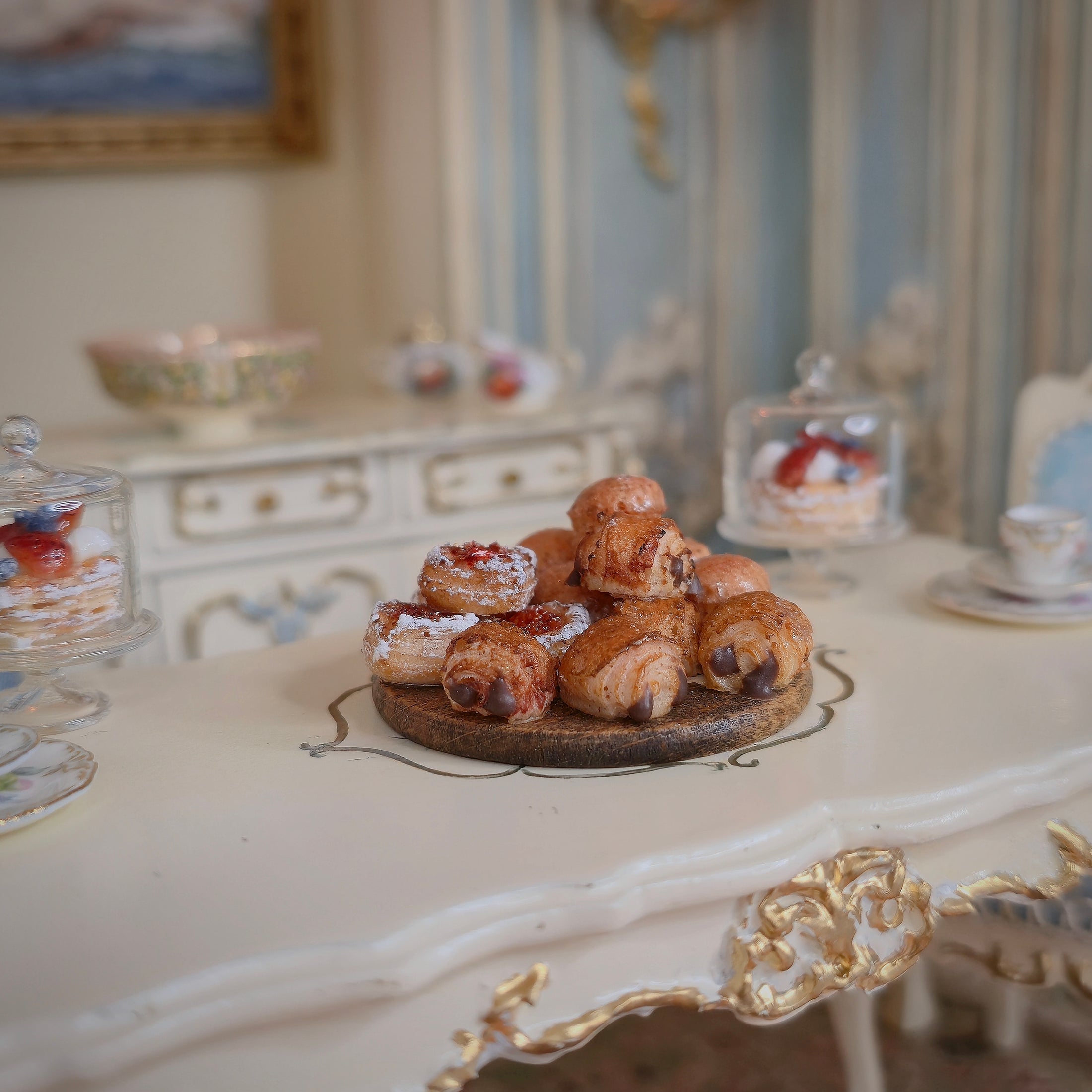 Miniature pastries on wooden serving board, on a table