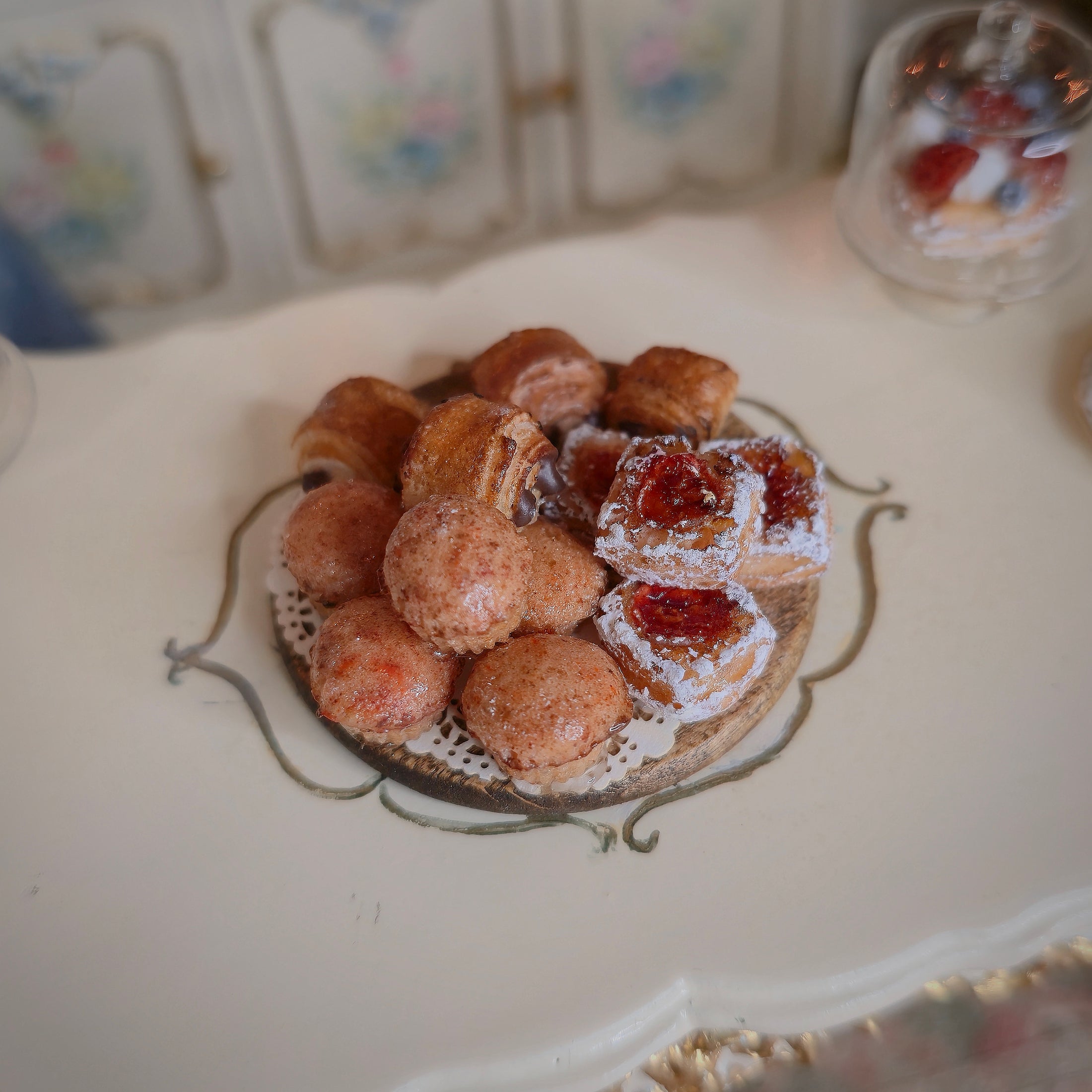 Miniature pastries on wooden serving board, on a table