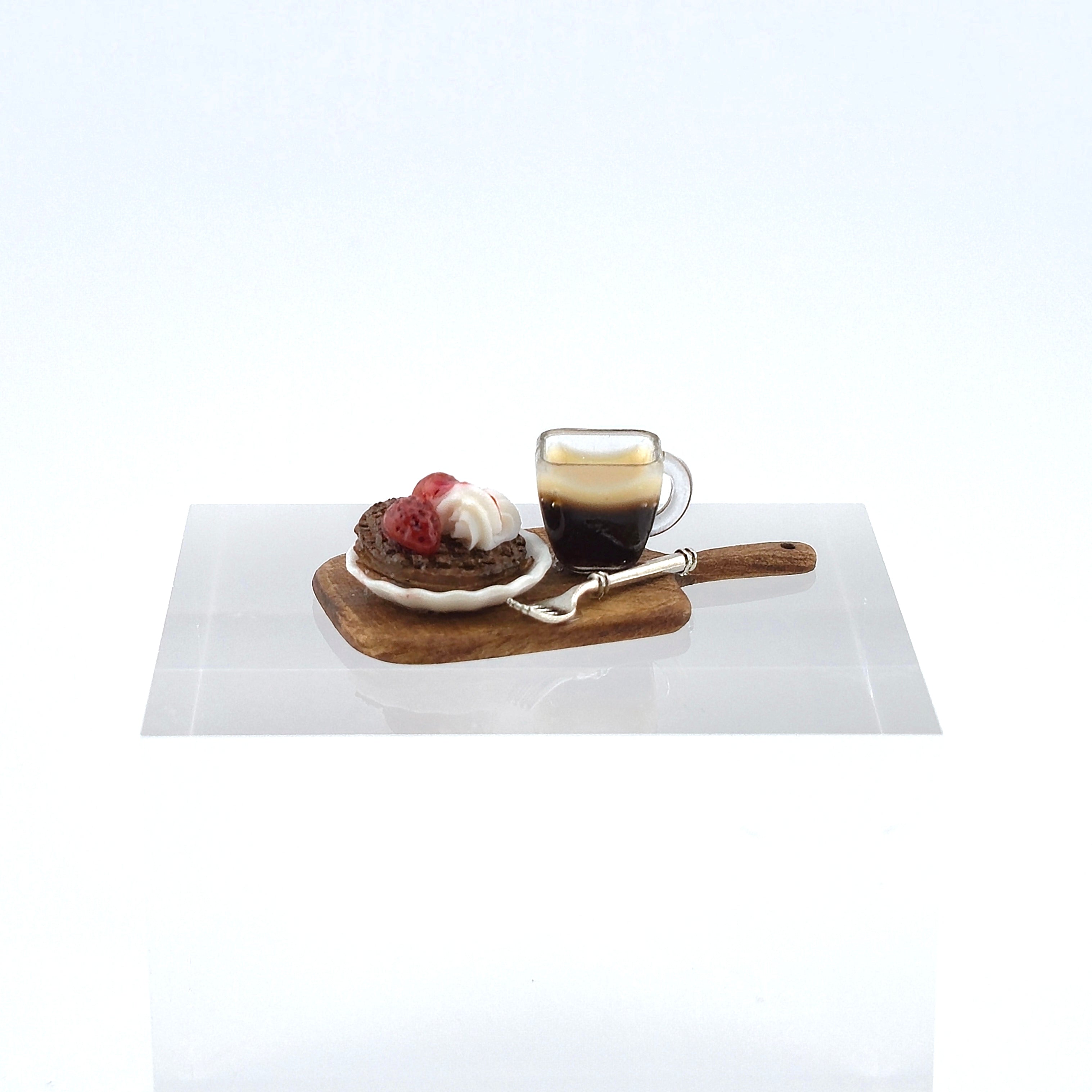 Café au lait with a dessert on a wooden tray on a white surface