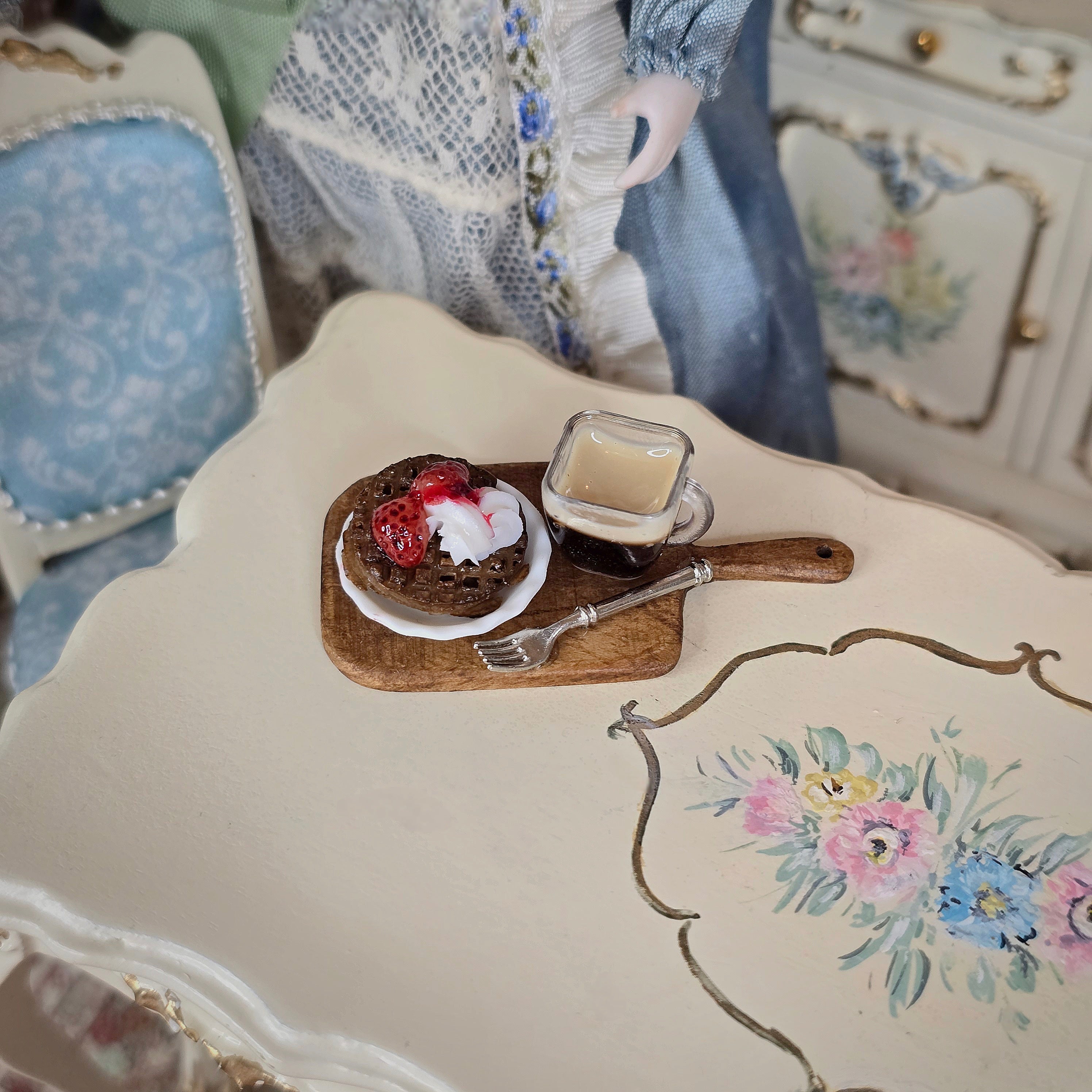Miniature dessert tray with cake and coffee on a floral tablecloth