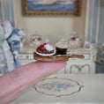 Load image into Gallery viewer, Miniature dessert with a glass of coffee on a cracker held between fingers, with a decorative background.
