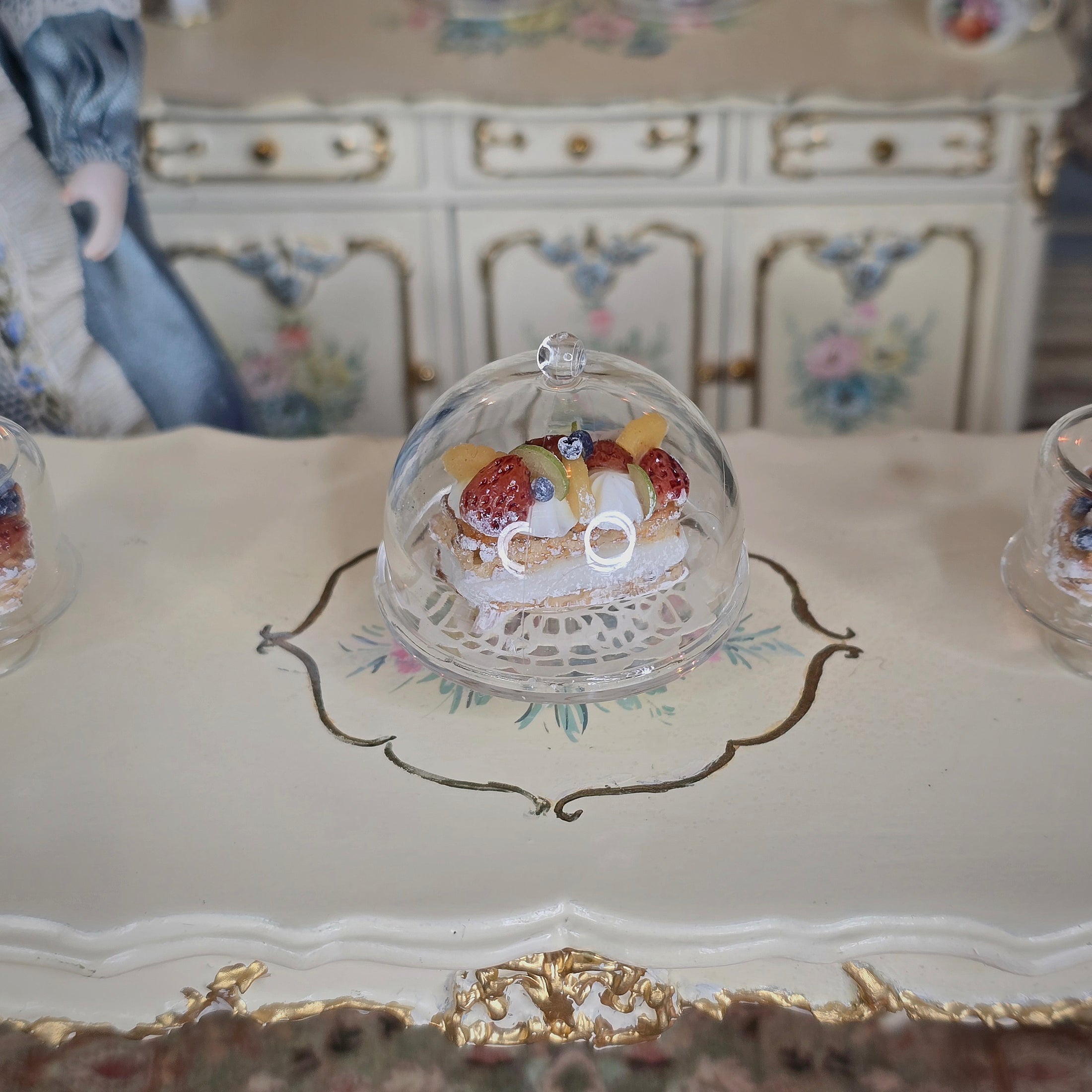 Decorative cake with a glass dome on an ornate table
